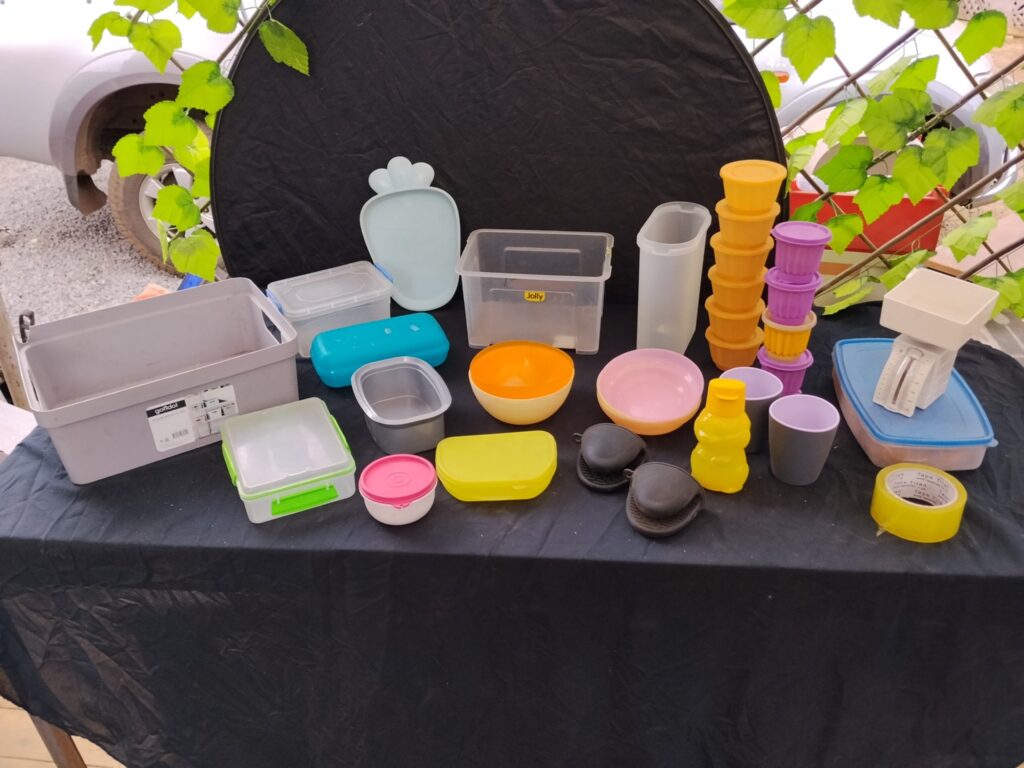 Mixed used plastic food-storage lot — assorted tubs, lids, small kitchenware + mechanical kitchen scale (some Tupperware)