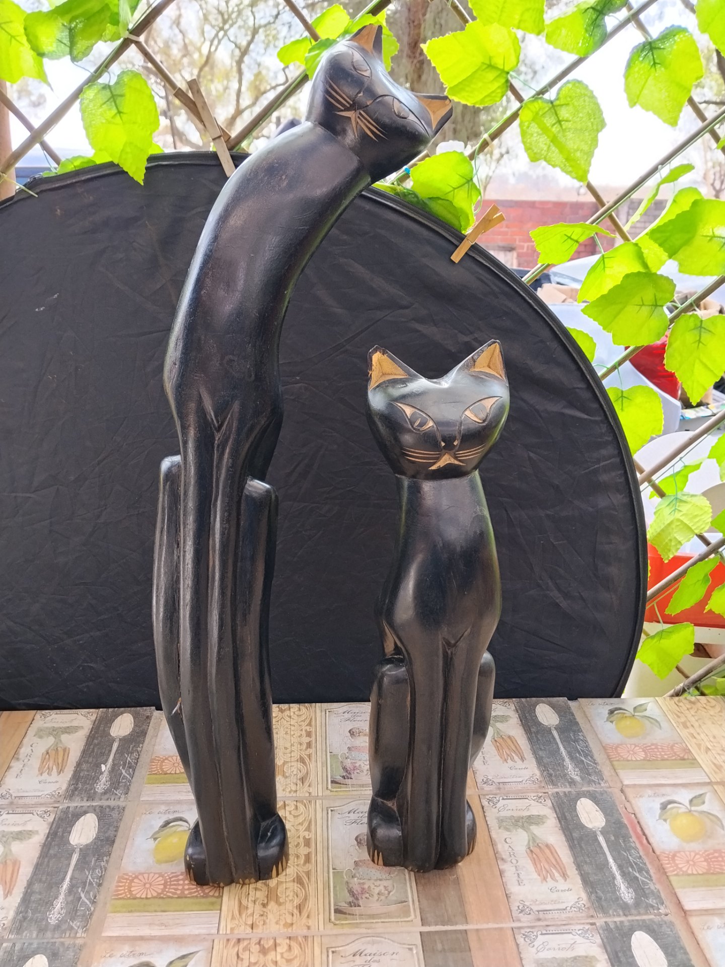 Pair of carved black-stained wooden cat sculptures (softwood) — decorative pair, worn finish
