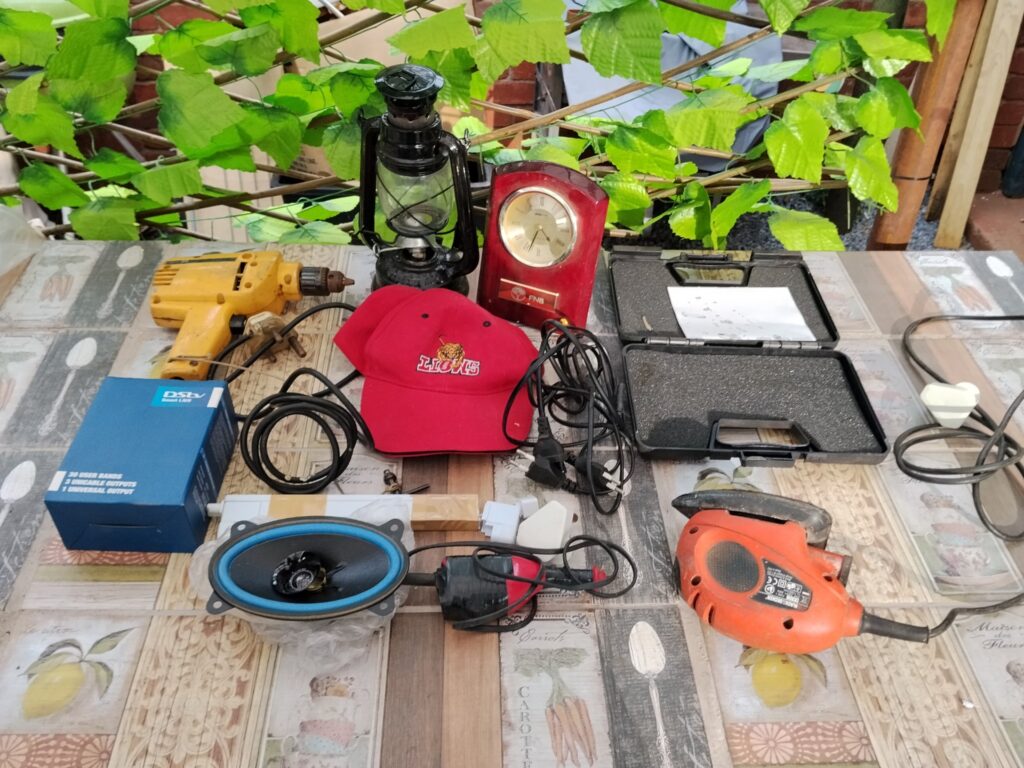 Mixed smalls lot — corded power tools, Black & Decker sander, DSTV Smart LNB (boxed), car speaker, kerosene lantern, desk clock & cables — used, needs attention