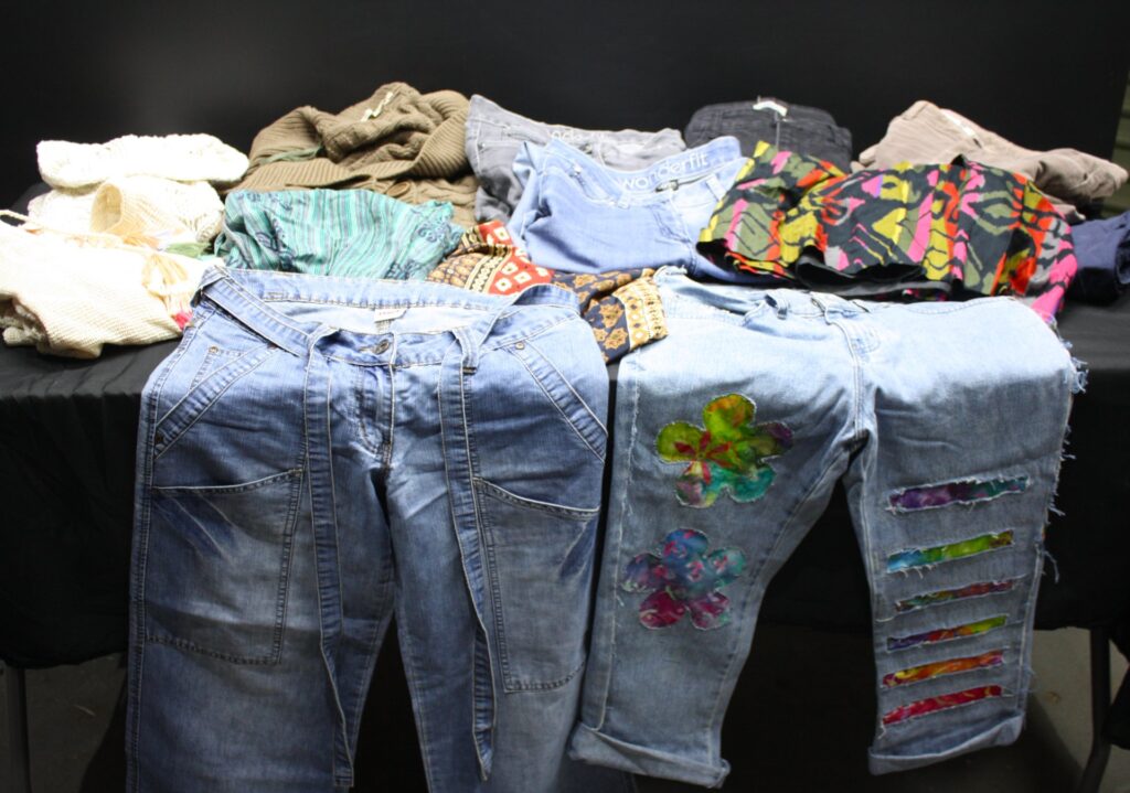 Mixed women’s clothing lot – approx. 25 pieces (denim, knit tops, patterned tops) – used, sold as-is