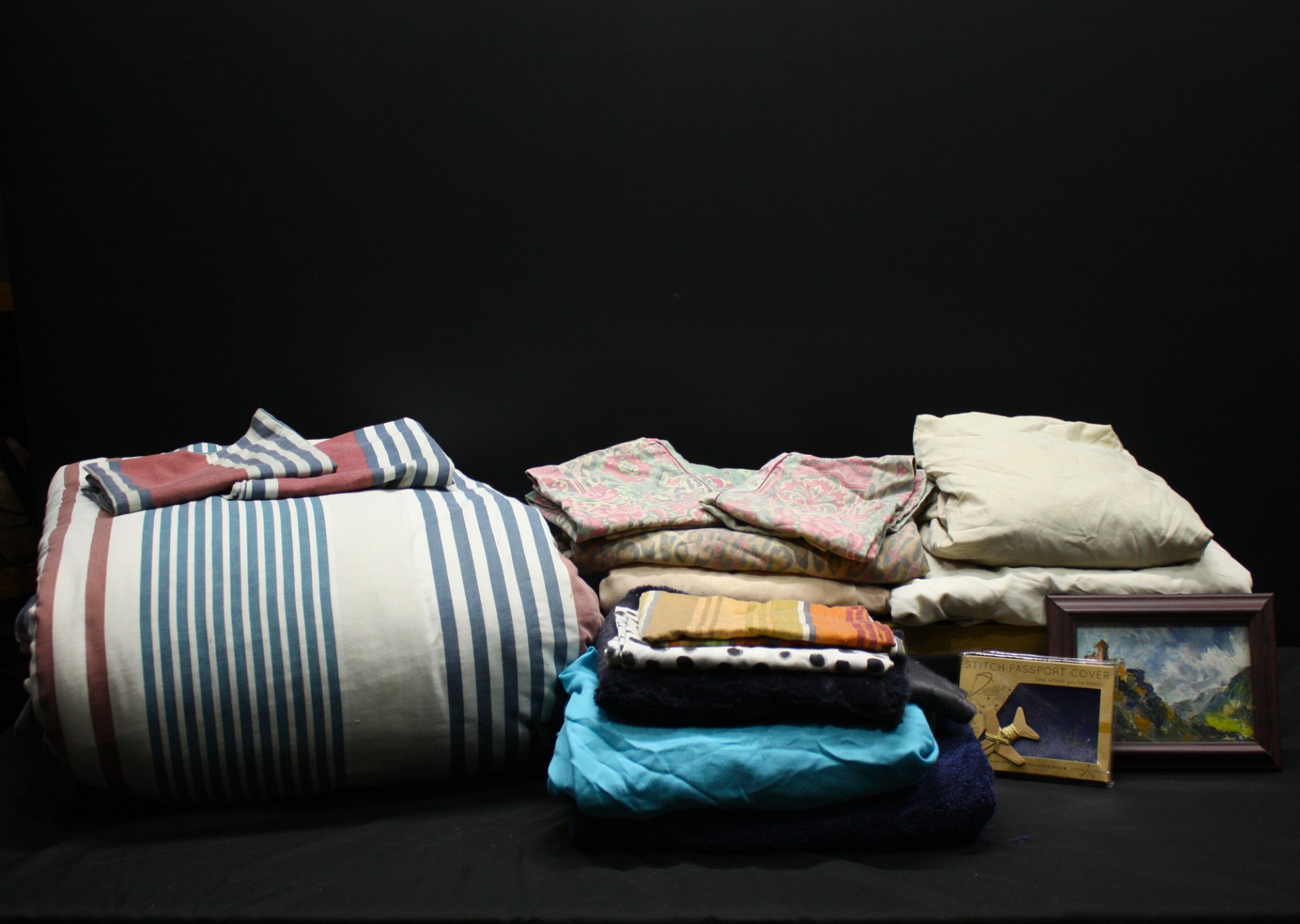 Mixed bedding and towels lot — striped duvet/cover, folded sheets, assorted towels plus framed picture & boxed ‘Stitch Passport Cover’ (used)