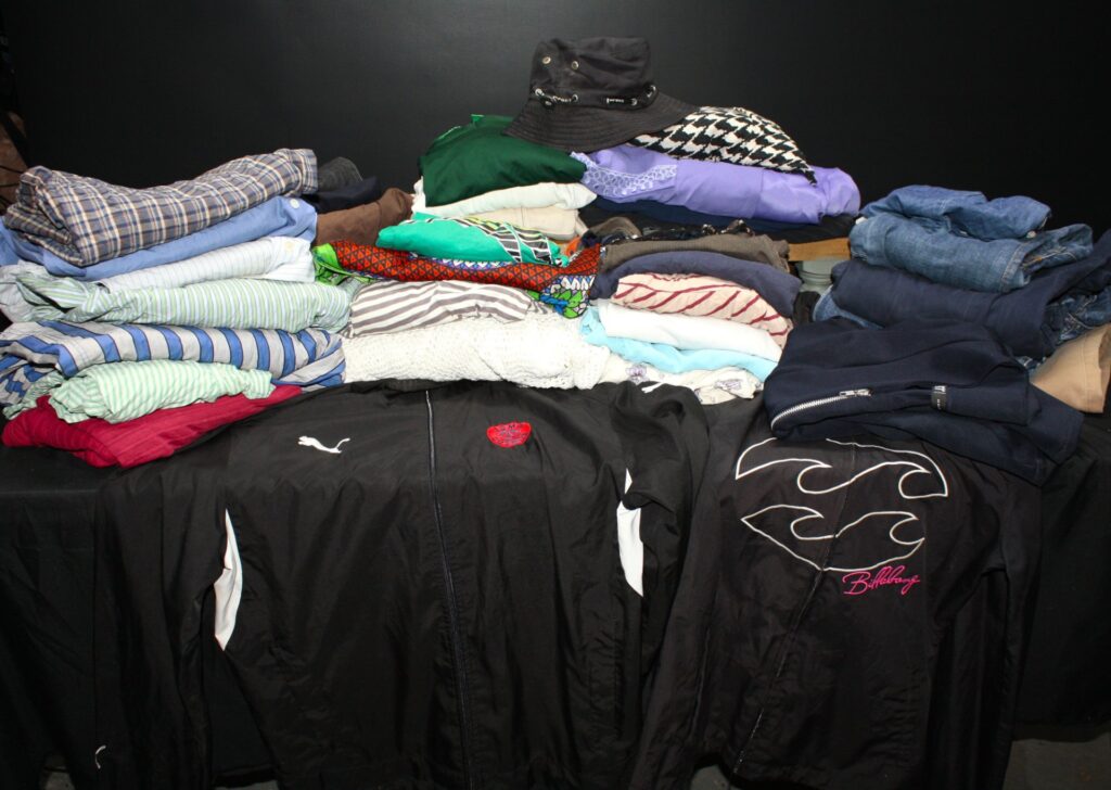 Mixed clothing lot — approx. 25 pieces (shirts, jeans, jumpers, jackets, accessories) — Puma & Billabong visible — sold as‑is