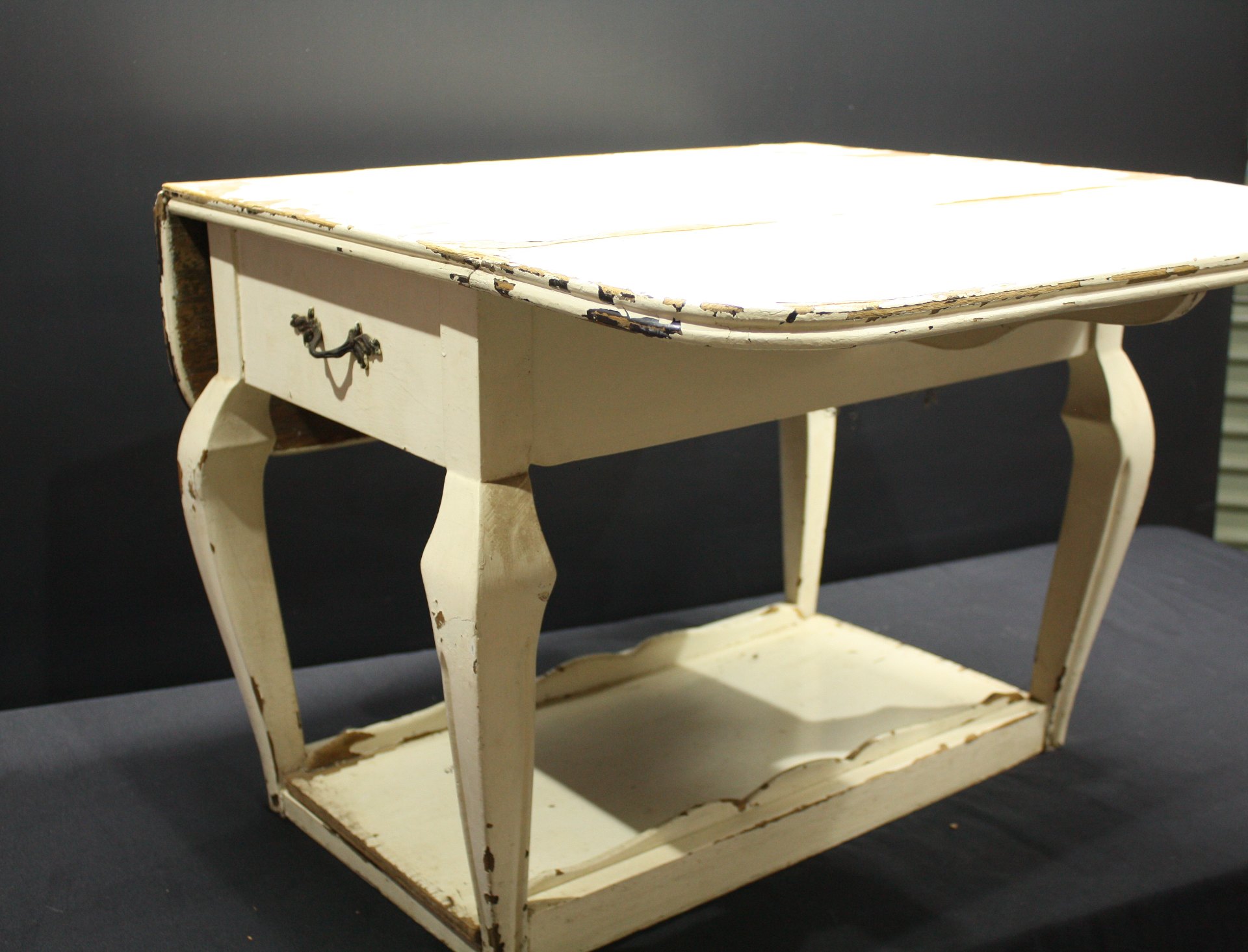 Small drop-leaf occasional/side table with drawer and lower shelf — heavy paint wear