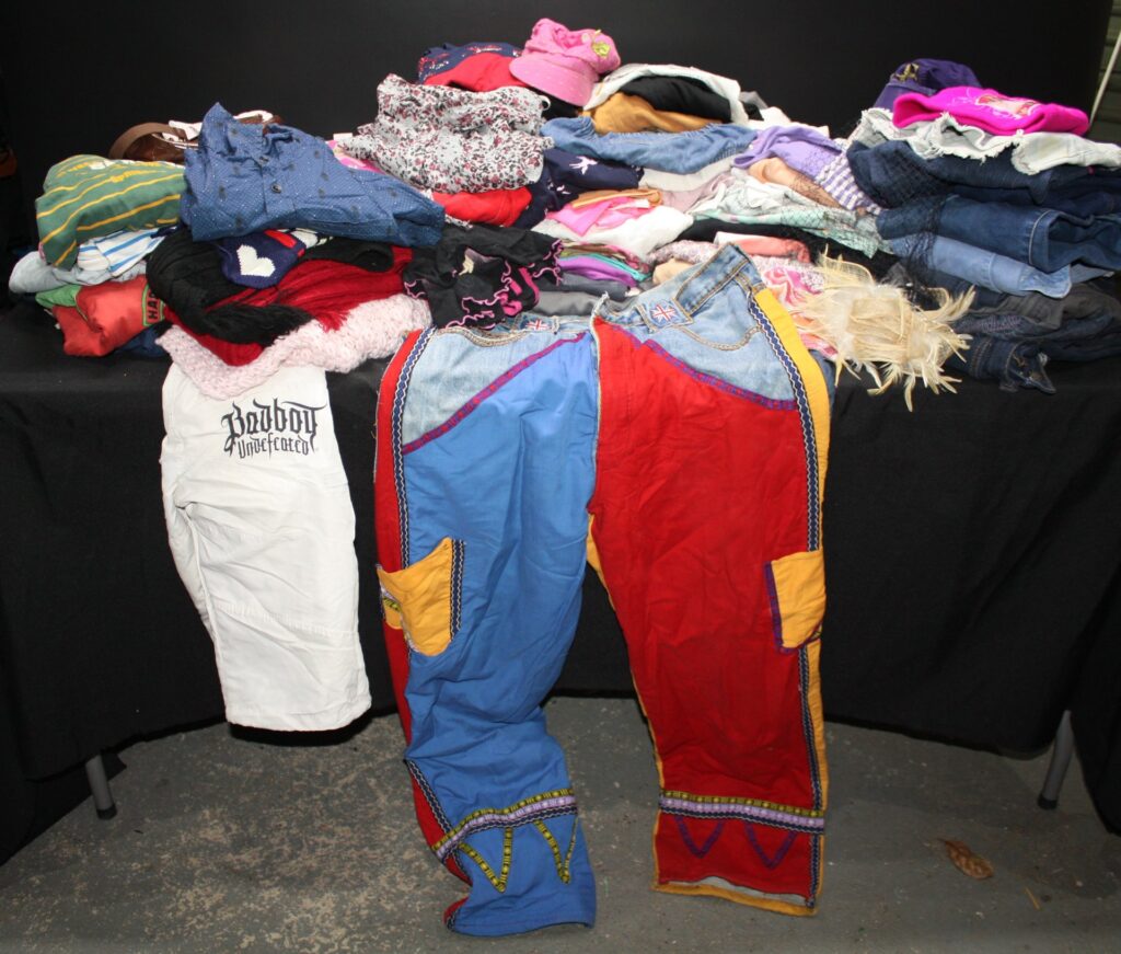 Bulk lot approx 25+ mixed used clothing – children’s/junior styles, colourful trousers, knits & hats (AS IS)