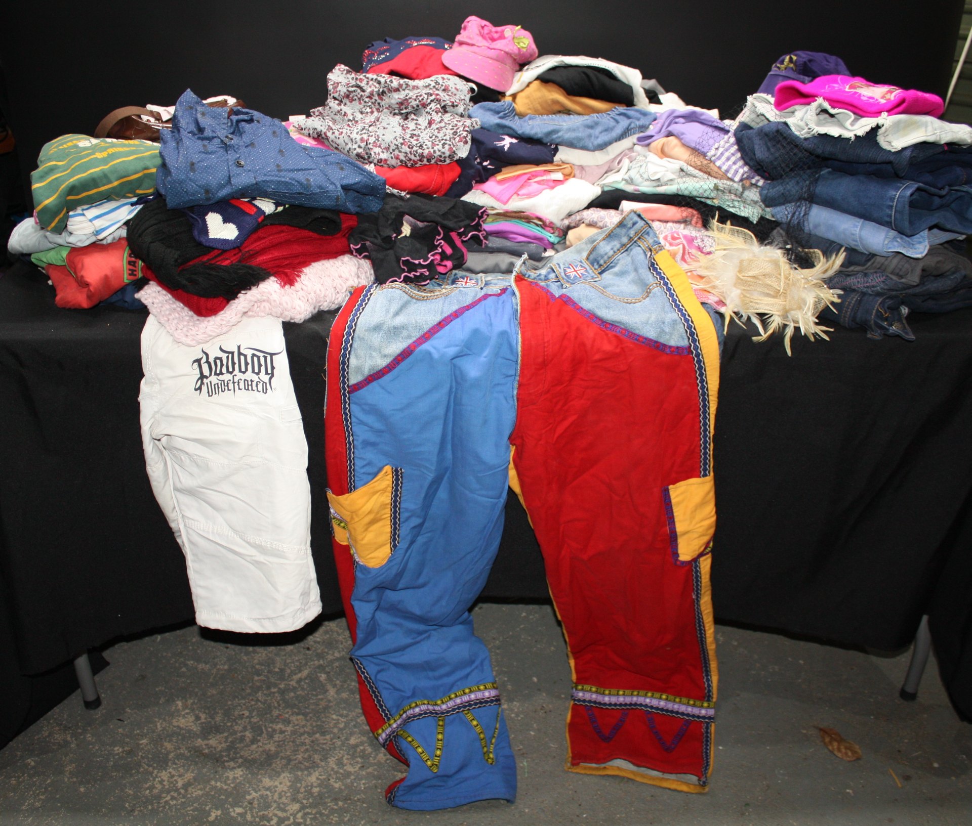 Bulk lot approx 25+ mixed used clothing – children’s/junior styles, colourful trousers, knits & hats (AS IS)