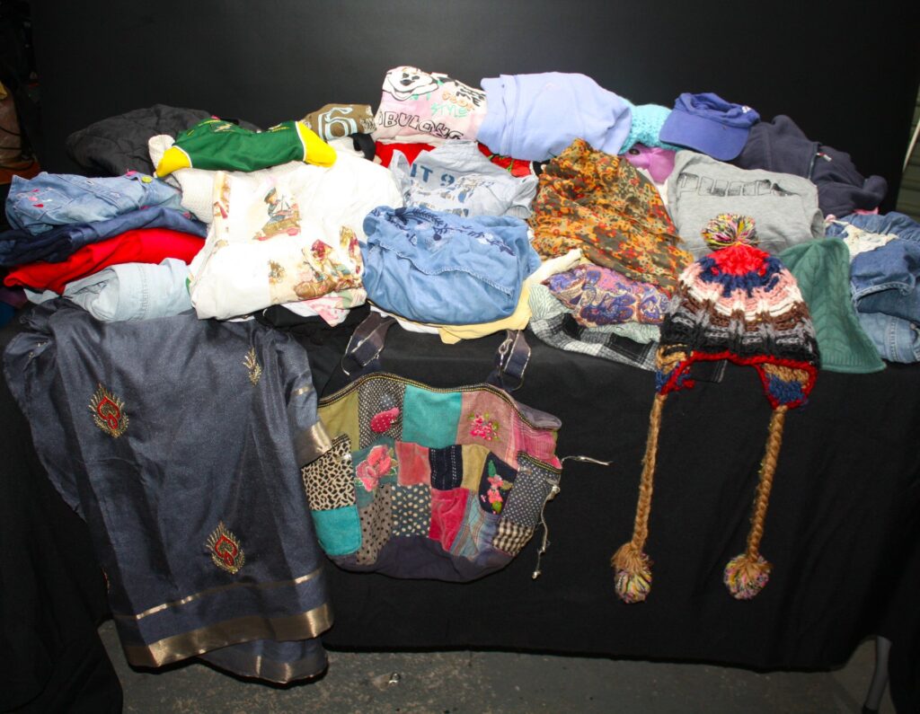 Bulk mixed clothing lot – approx 25+ pieces with accessories (Puma sweatshirt, patchwork bag, knitted hats) — used, visible wear & stains