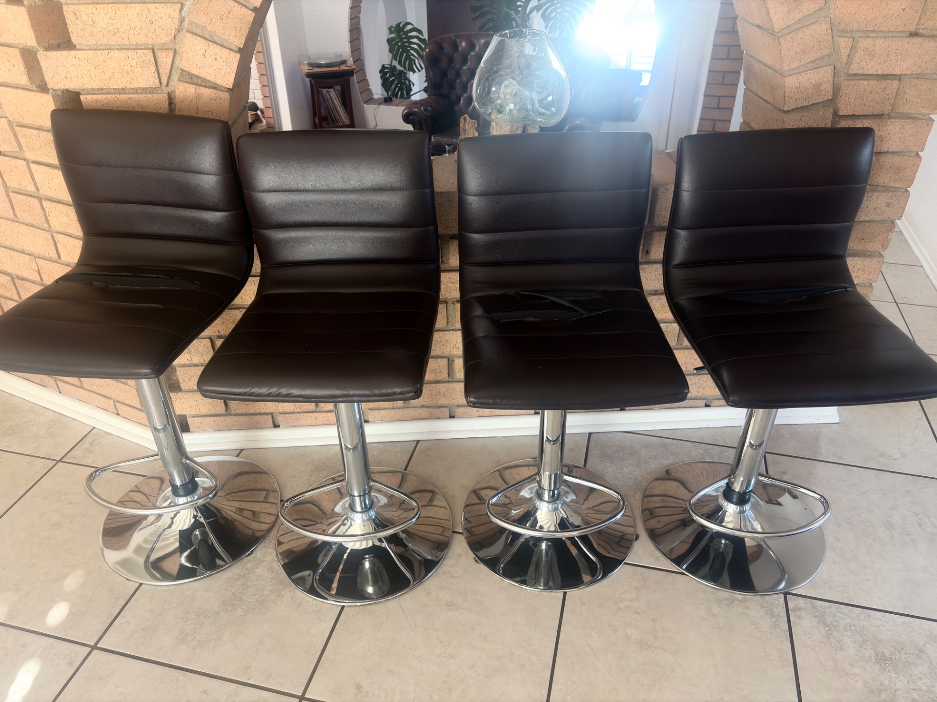 Set of 4 Black Faux‑Leather Gas‑Lift Swivel Bar Stools — Chrome Bases, Torn Upholstery