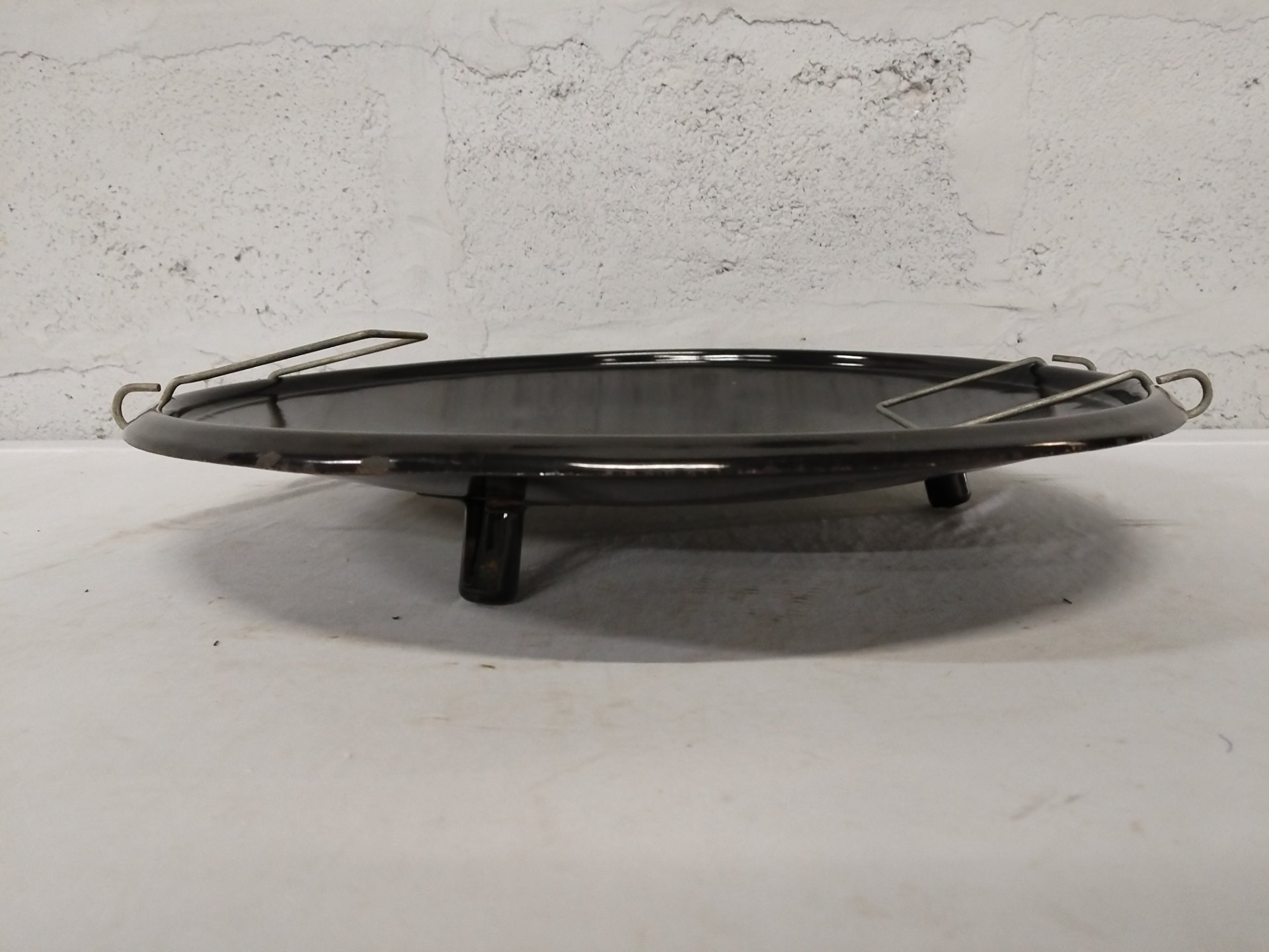 Black enamel three‑leg trivet / gas burner plate with two removable wire pot rests