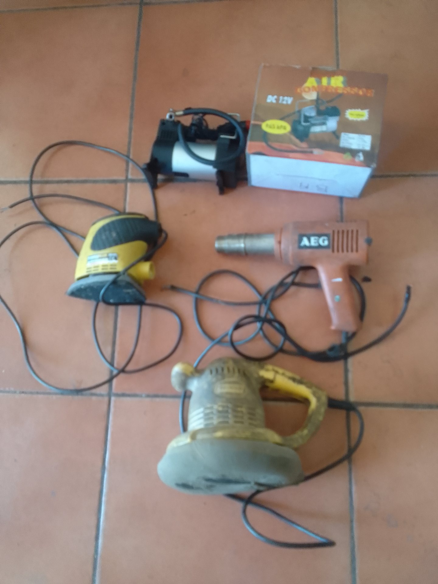 Lot of 4 assorted corded power tools — AEG heat gun, 2 sanders + 12V compressor box (NOT WORKING)
