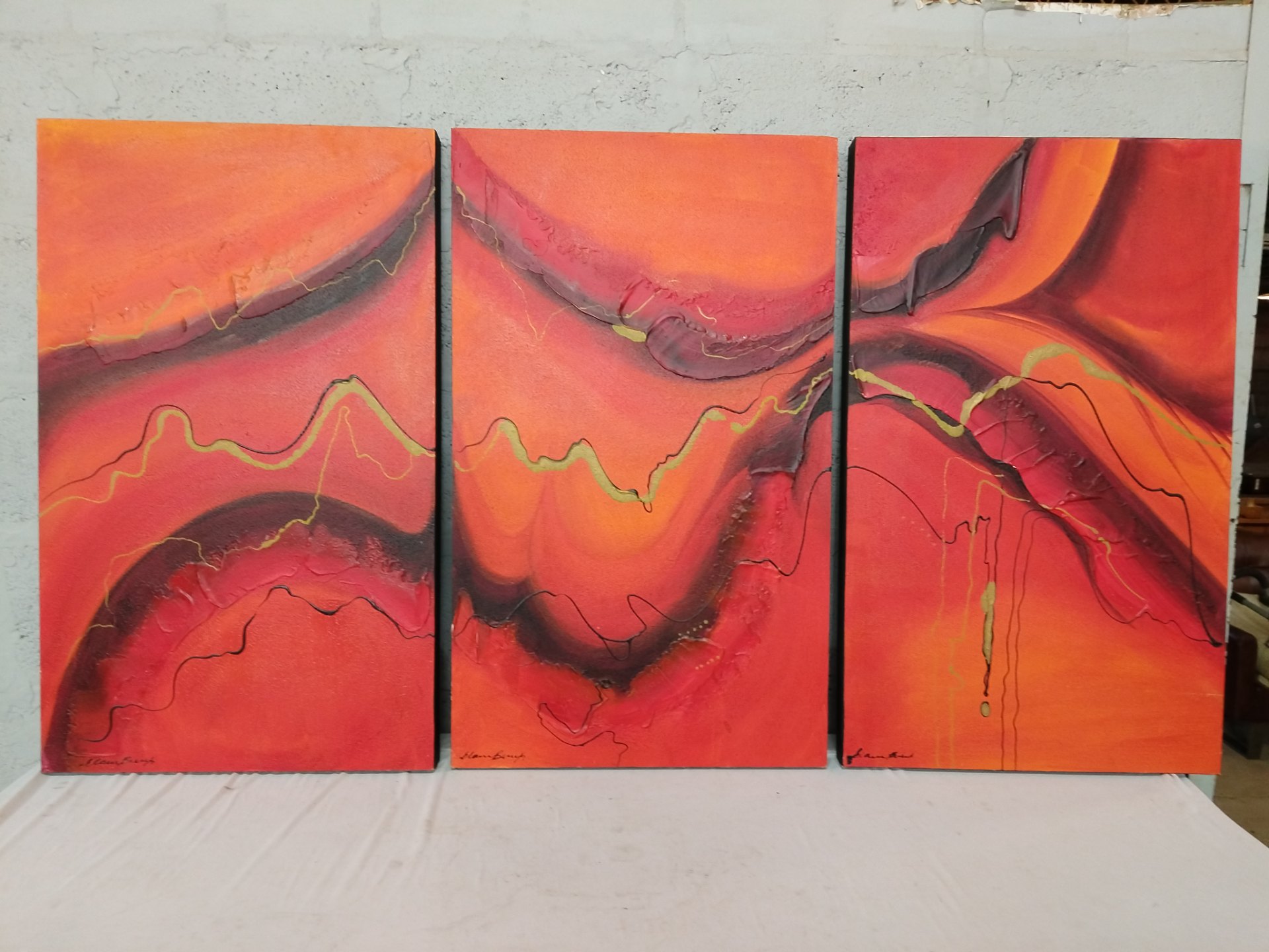 Signed abstract triptych — three stretched canvases, bold red-orange impasto texture