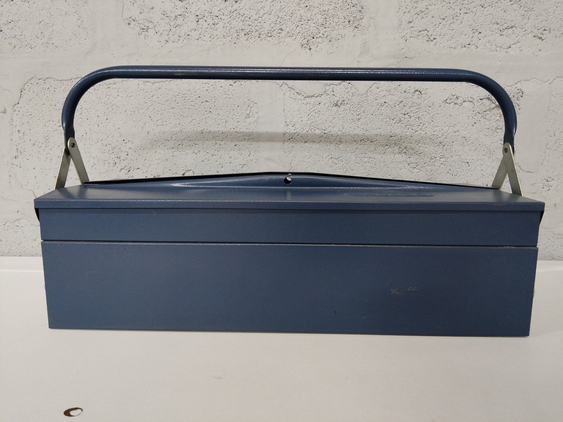 Blue metal cantilever toolbox – portable with locking latch, dented lid & surface wear