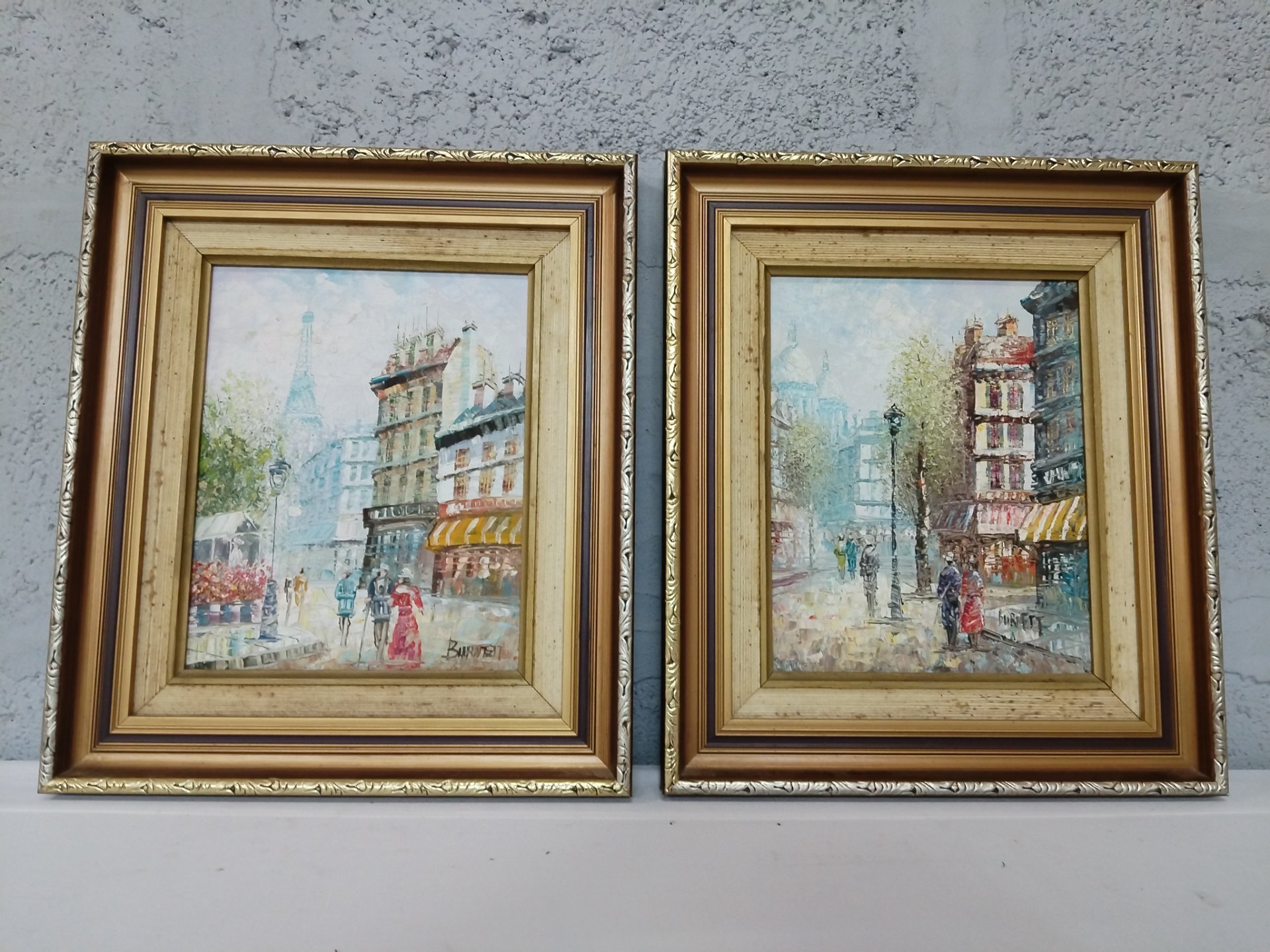 Pair of framed impasto street-scene paintings signed ‘Burnett’ — gilt moulded frames
