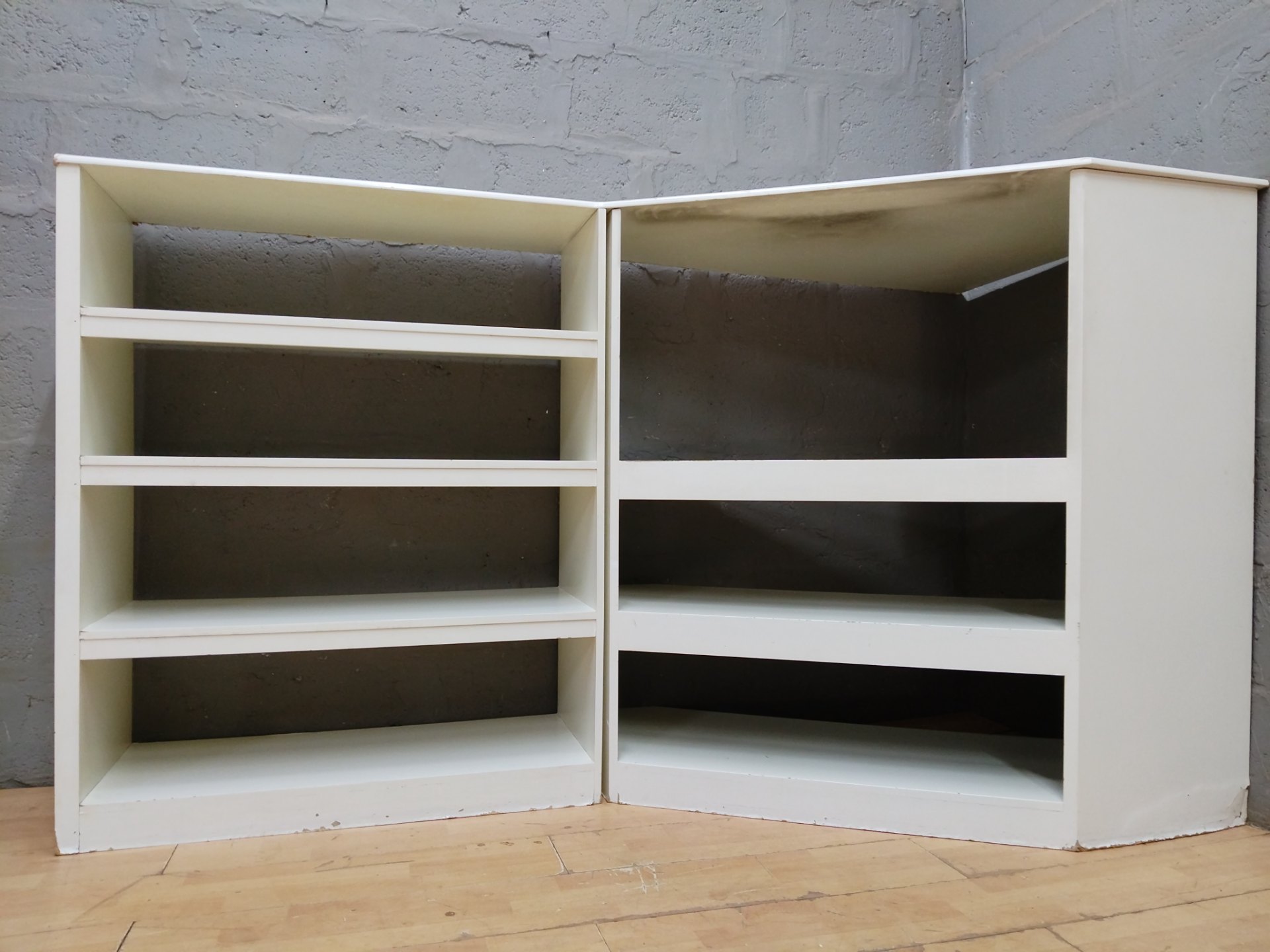 Corner display shelving unit — joined two-section white MDF/particleboard, multiple open shelves