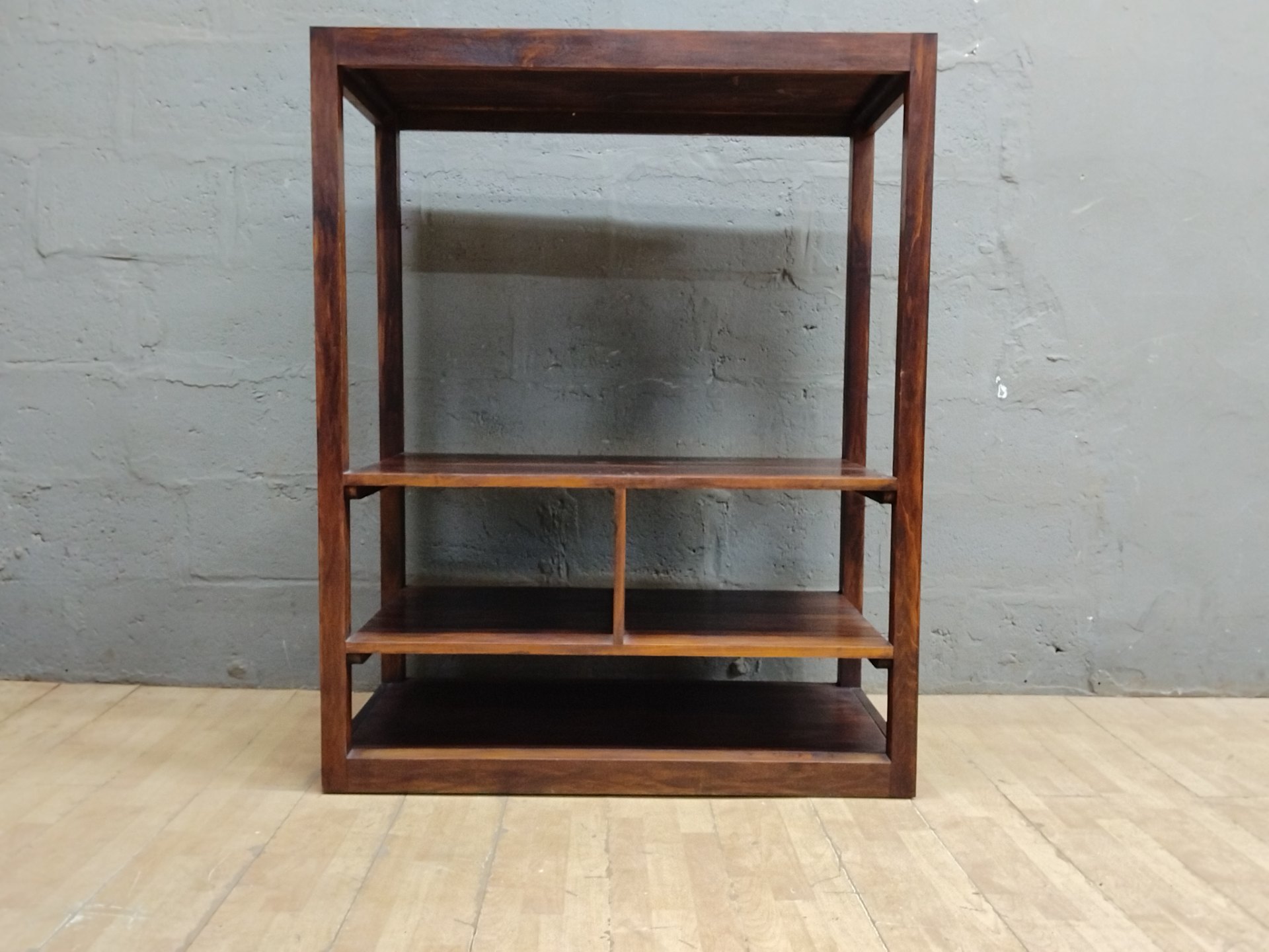 Open wooden shelving unit / bookcase — multi-shelf, fixed shelves, visible surface wear