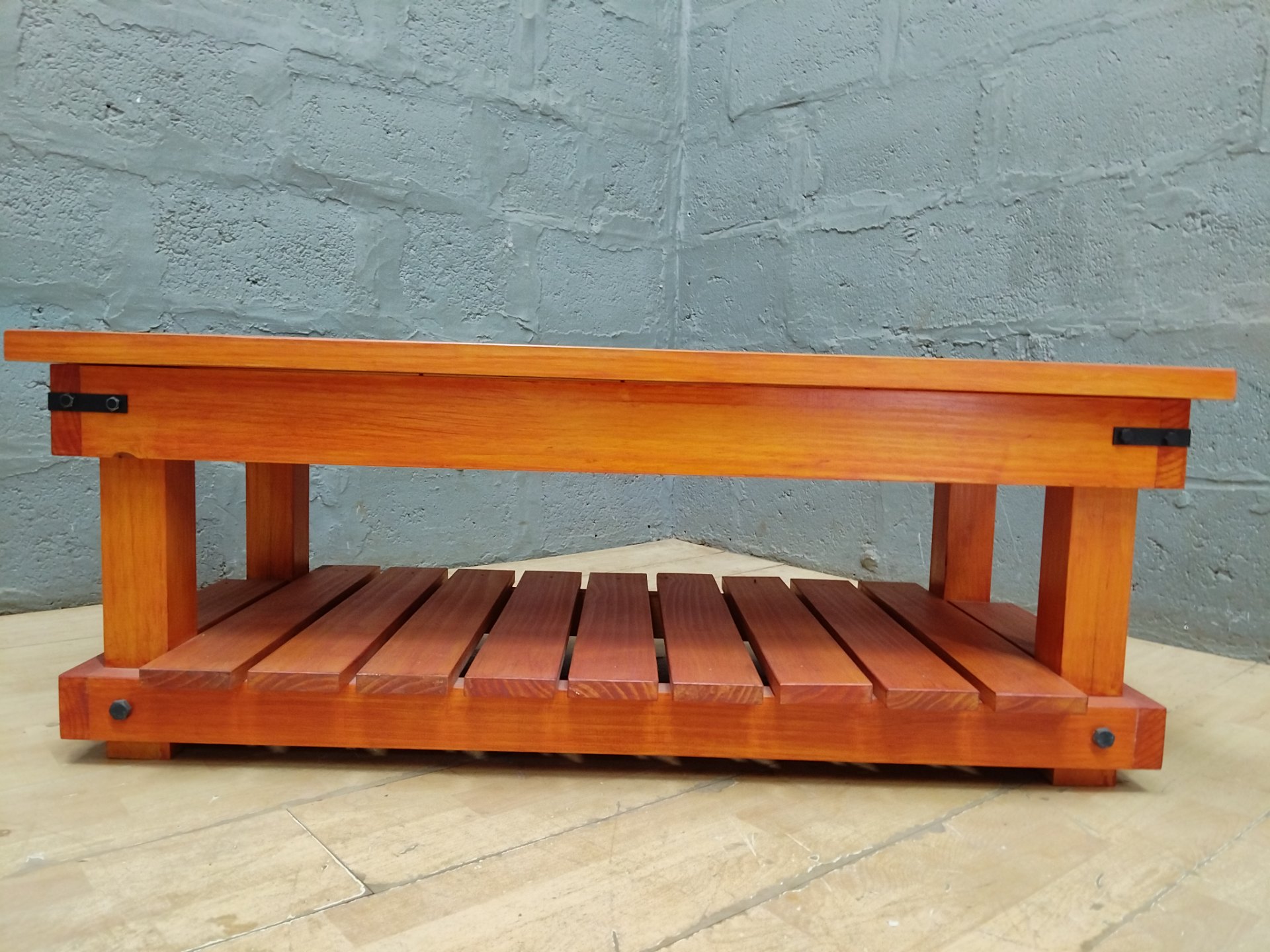 Solid wooden low coffee table with slatted shelf & metal corner brackets — 120 x 57 x 43 cm