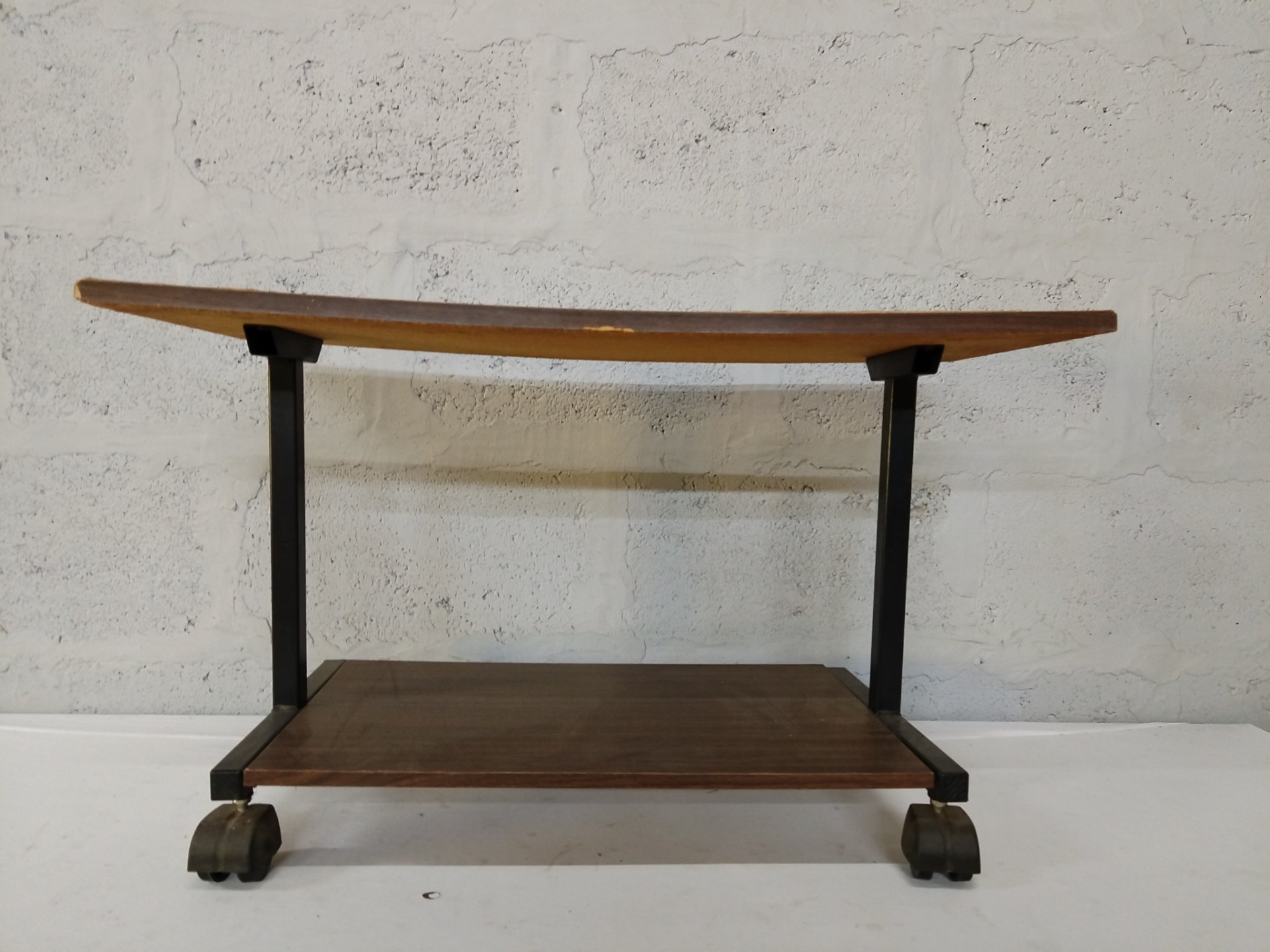 Two-tier wood-look trolley on castors — black metal frame, used with edge chips