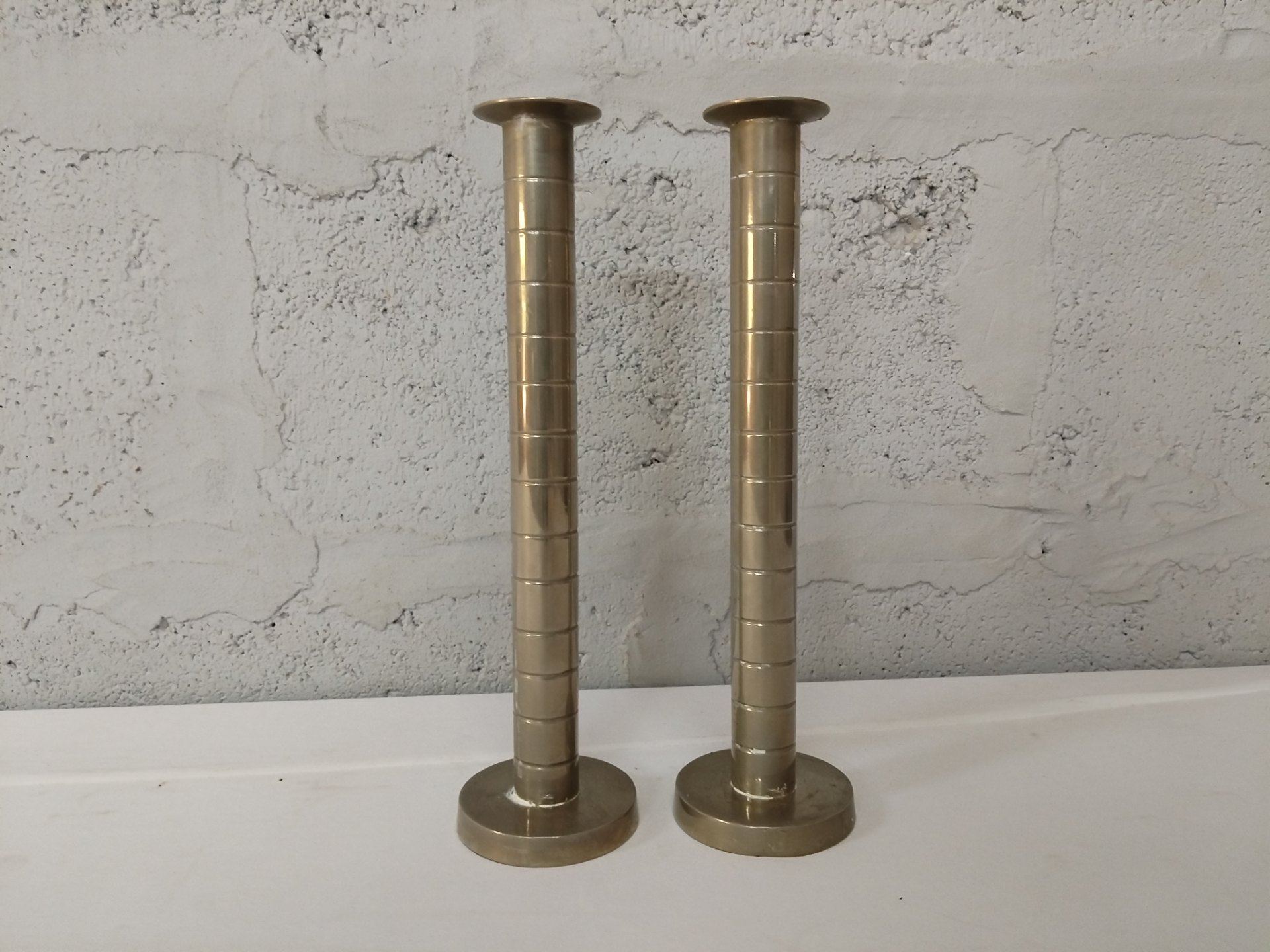Pair of brass‑coloured candlesticks, stepped column detail — 30 cm tall (used, visible repairs & wear)