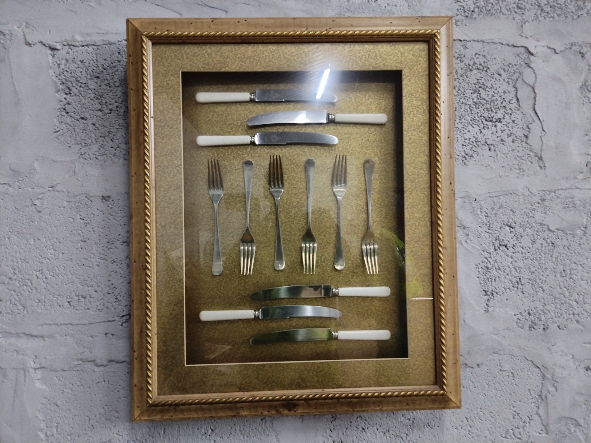 Framed shadow-box wall display: 6 knives (white handles) & 6 forks — decorative gilt frame