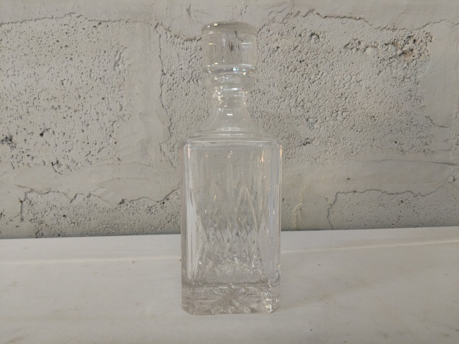 Clear cut‑glass square decanter with matching stopper (approx. 25 cm)