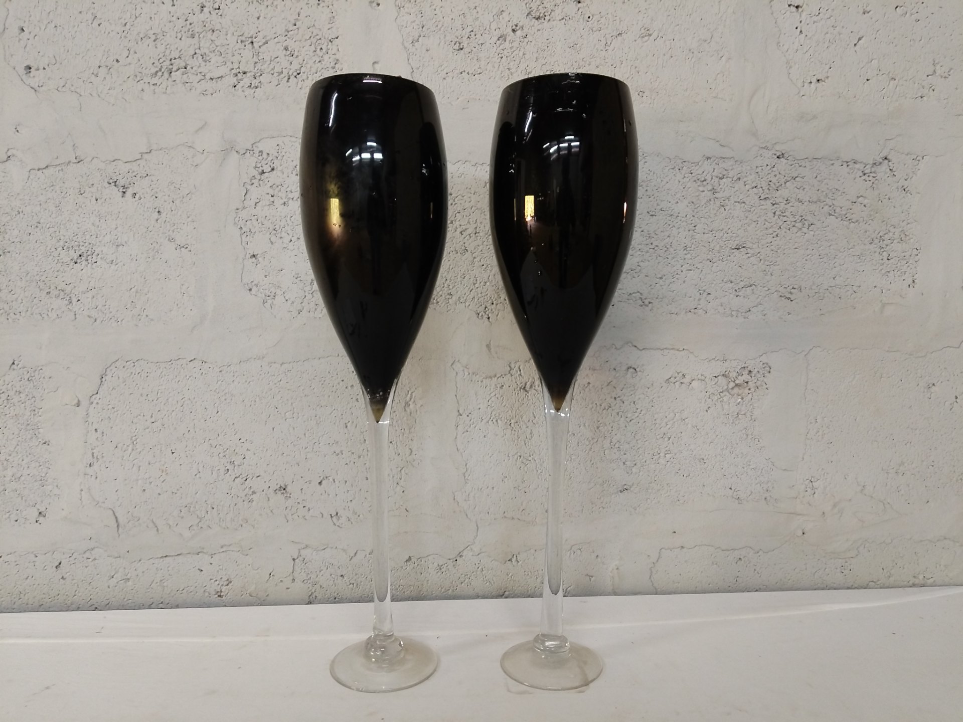 Pair of tall black-tinted champagne flutes with clear stems (used, rim chips)