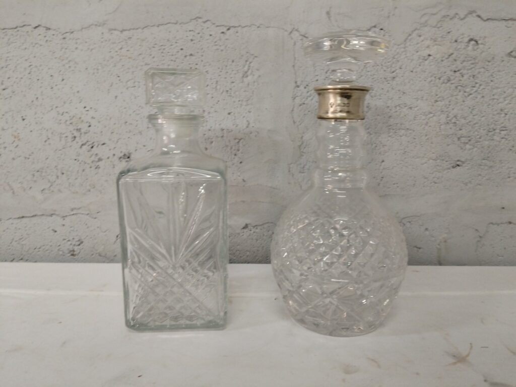 Pair of Cut-Glass Decanters with Stoppers – one stopper with hallmarked sterling silver collar