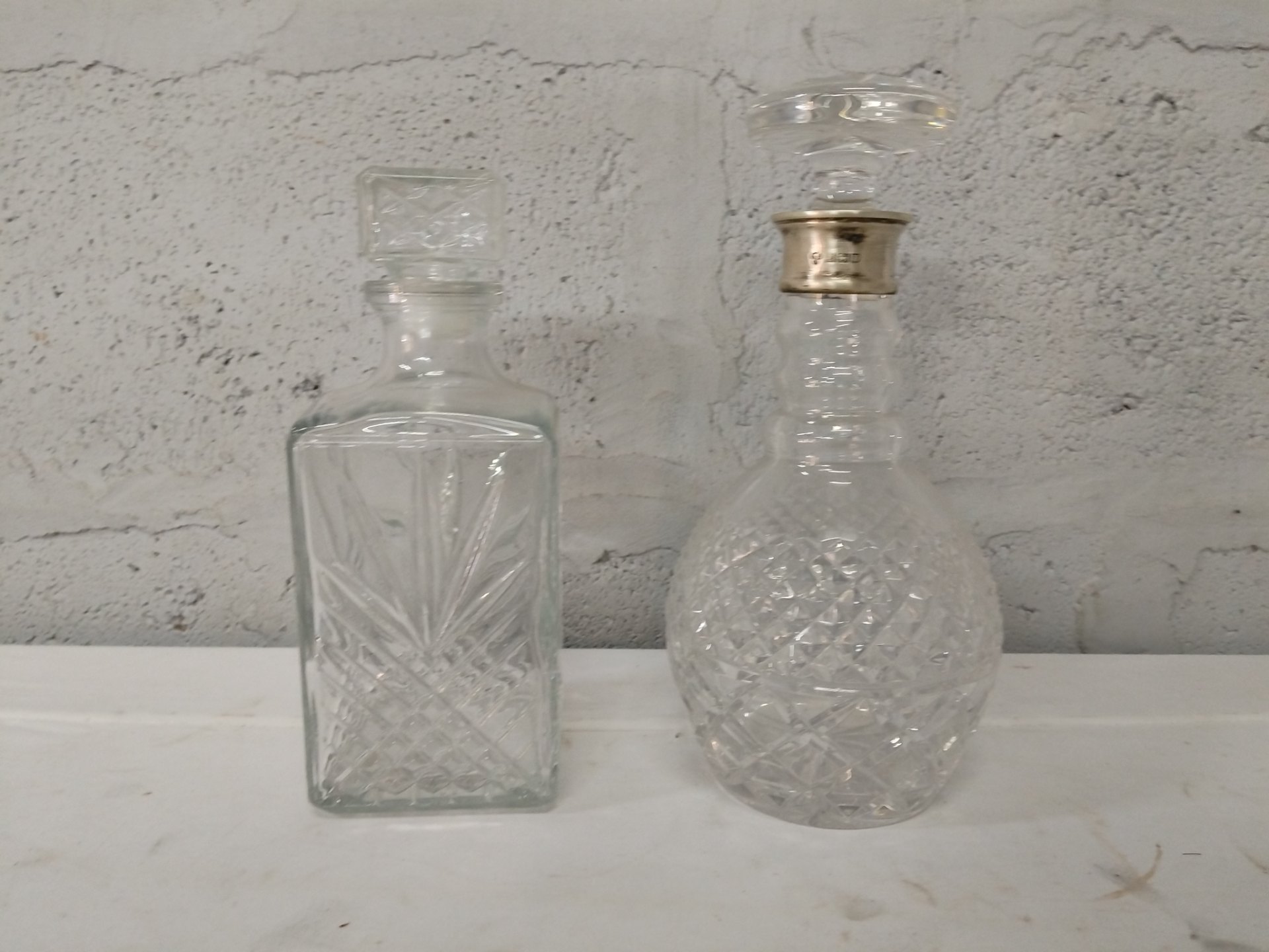 Pair of Cut-Glass Decanters with Stoppers – one stopper with hallmarked sterling silver collar