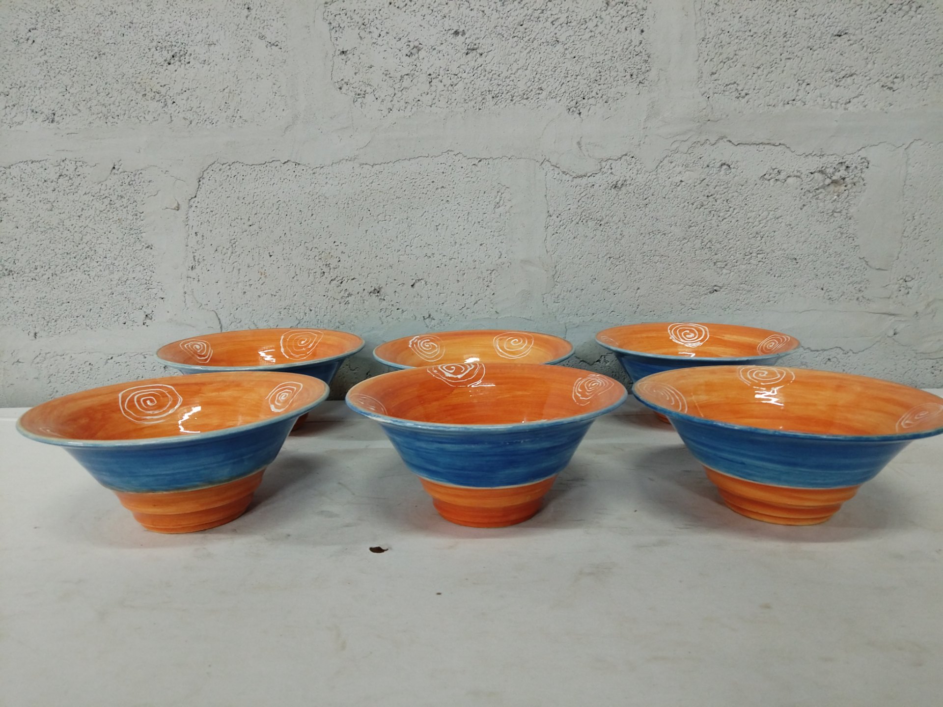 Set of 6 hand‑decorated glazed ceramic bowls — orange interior / blue exterior, base marked HCB, approx 16cm