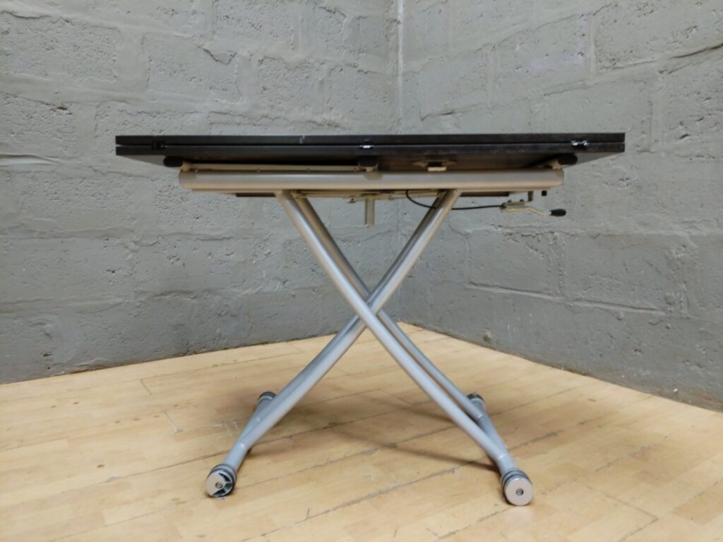 Folding adjustable X‑frame table with dark wooden top – one caster broken