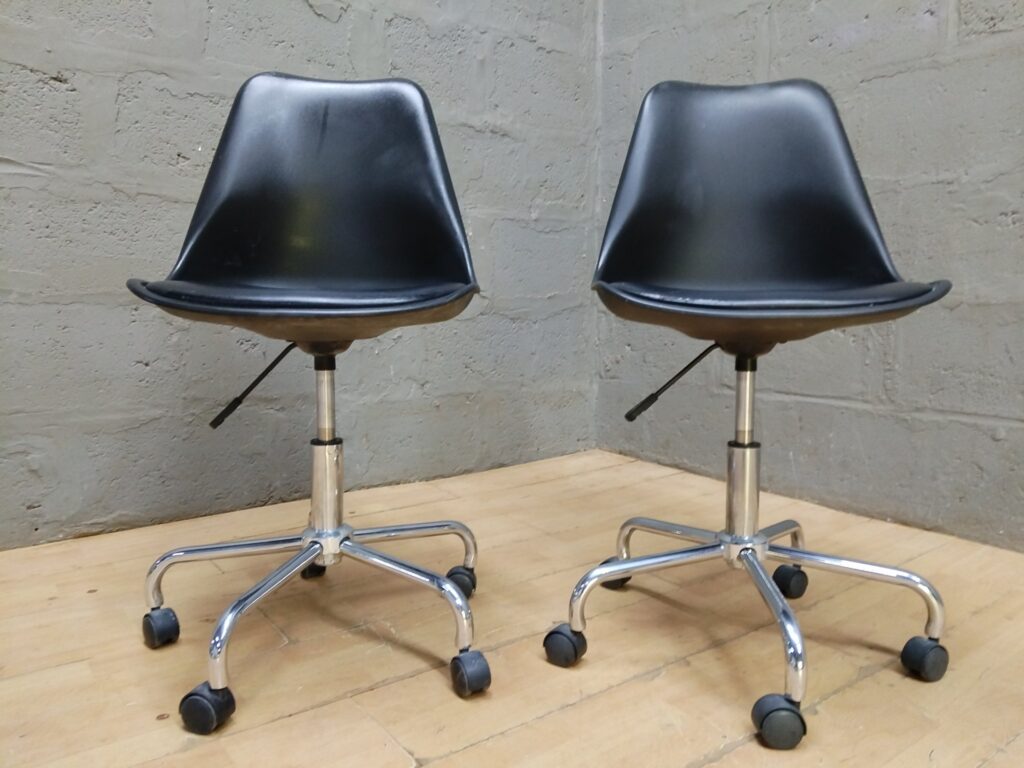 Pair of black height-adjustable swivel office desk chairs on chrome 5‑star bases