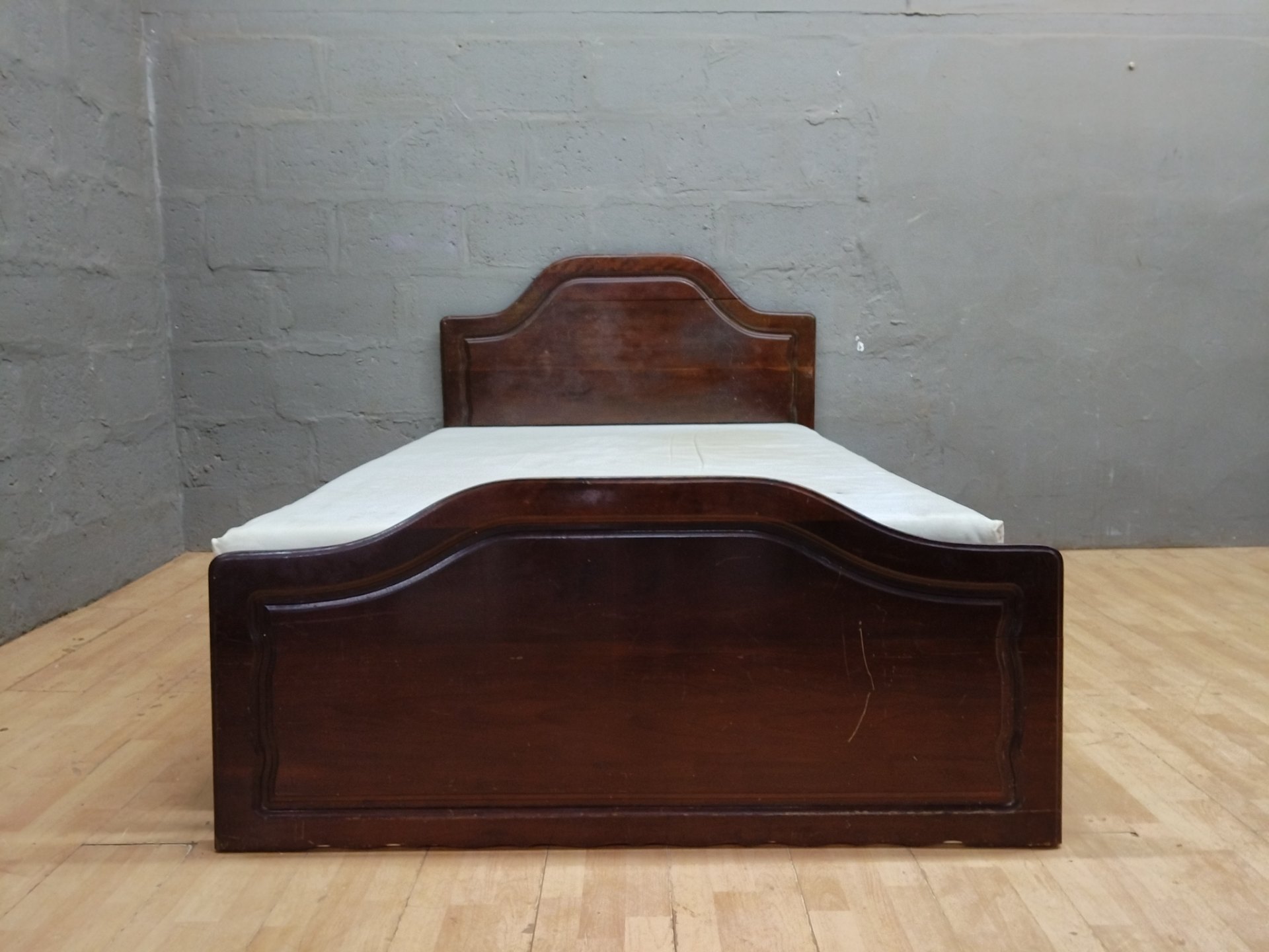 Double wooden bed frame with shaped headboard & stained mattress — 138 x 200 x 114 cm