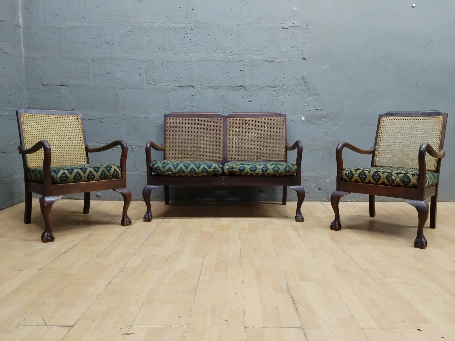 Three-piece wooden seating set — two armchairs + two-seat cane settee, carved legs, loose cushions (needs restoration)