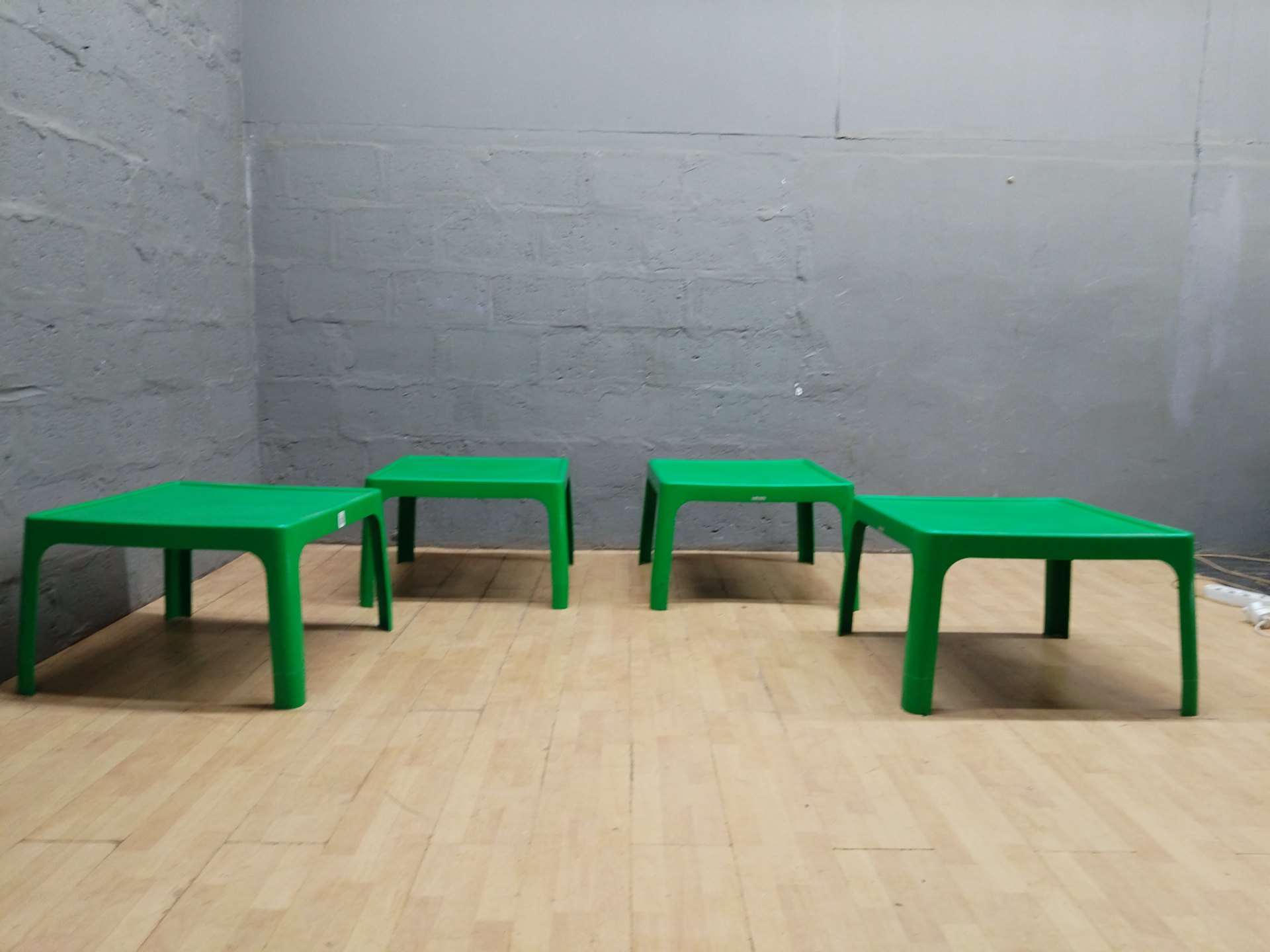 Set of 4 low green plastic square tables / stools — used, minor cosmetic wear
