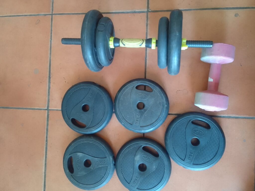 Mixed lot adjustable dumbbell set + pink vinyl dumbbell — plastisol plates (marked 2.5kg, 3kg), threaded bar & spin-lock collars