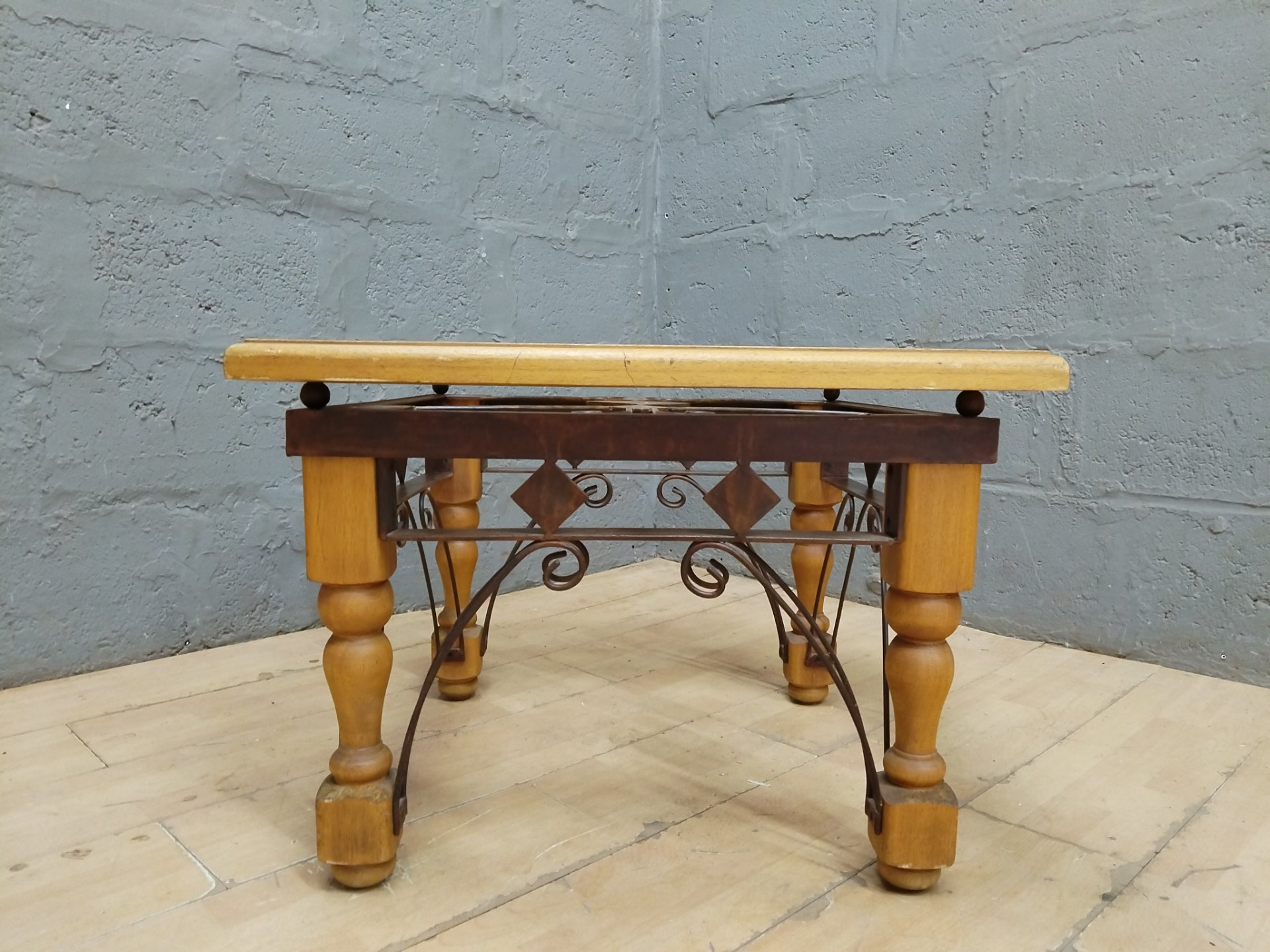 Square wooden occasional/side table with decorative wrought-iron base — top insert missing