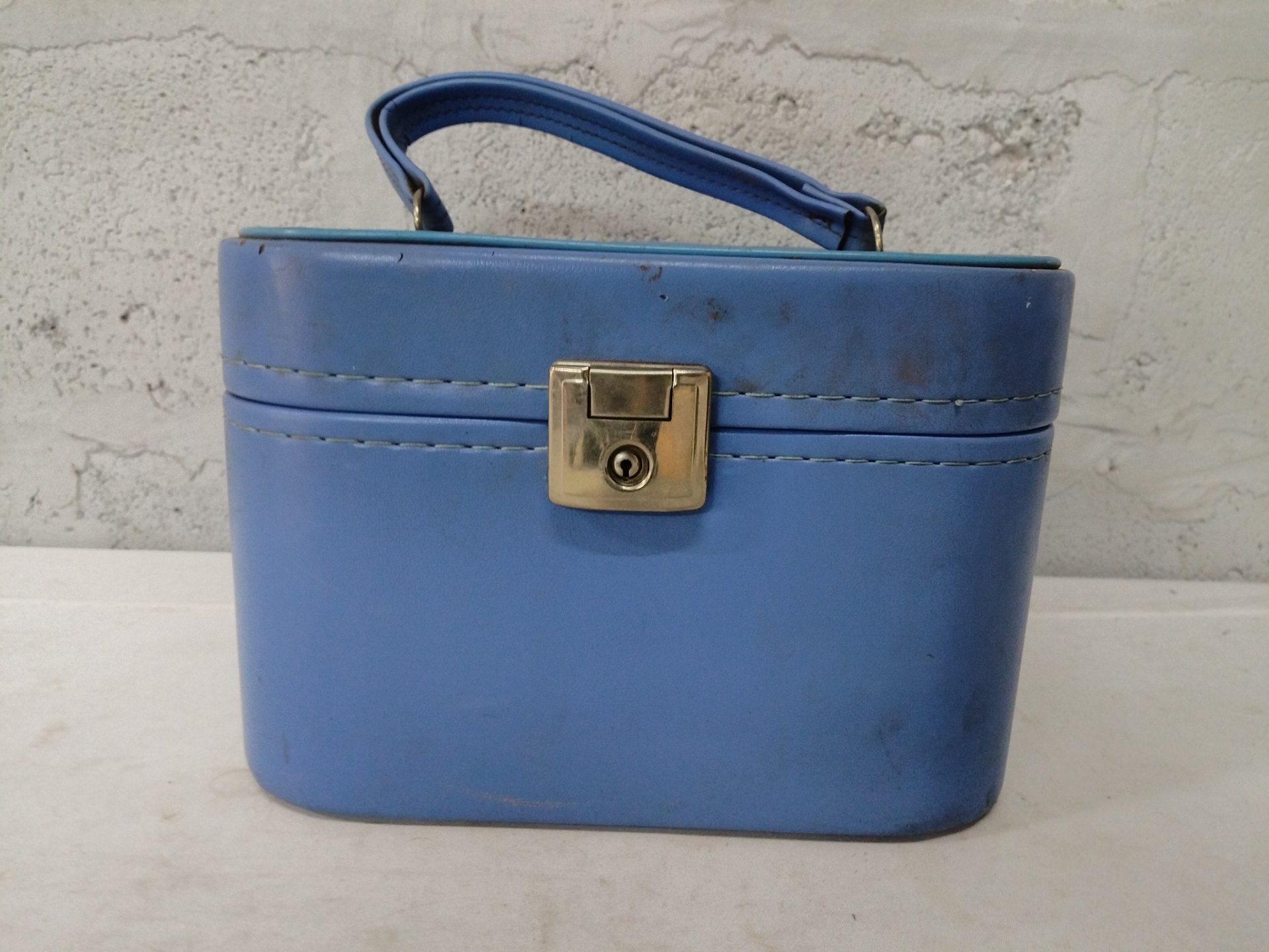 Small blue hard-sided travel/vanity case — single, lock with key included, worn interior
