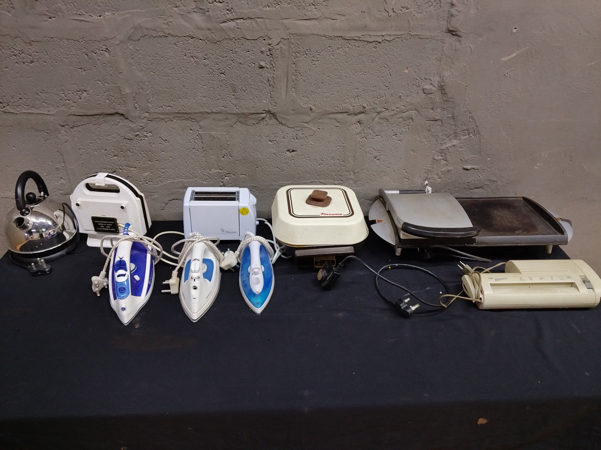 Mixed lot of 9 small kitchen appliances – irons, sandwich/toast makers, kettle, griddle, shredder (heavily used, declared working)