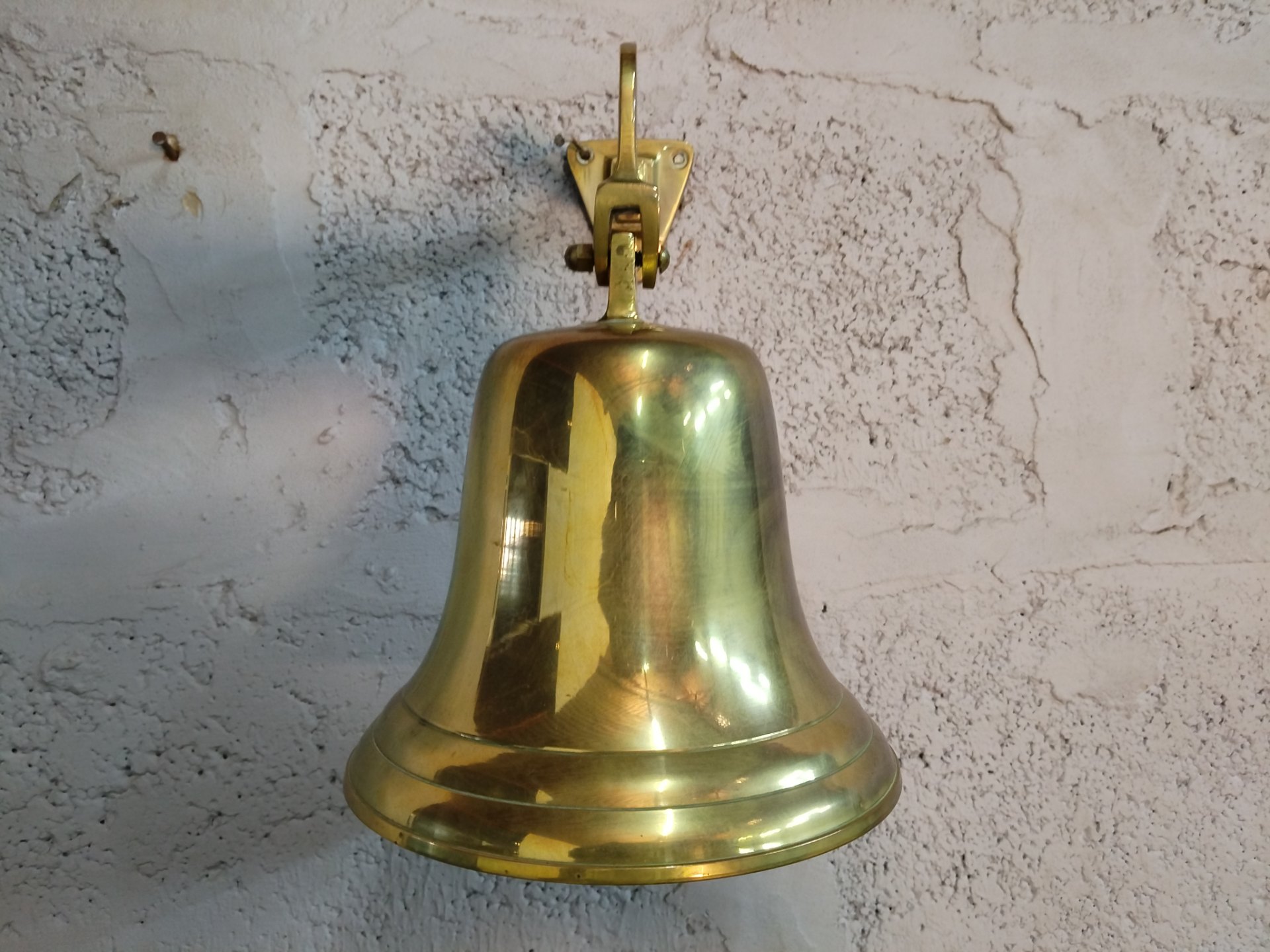 Wall-mounted polished brass-finish bell with pivot bracket — D 20 x H 23 cm, rings