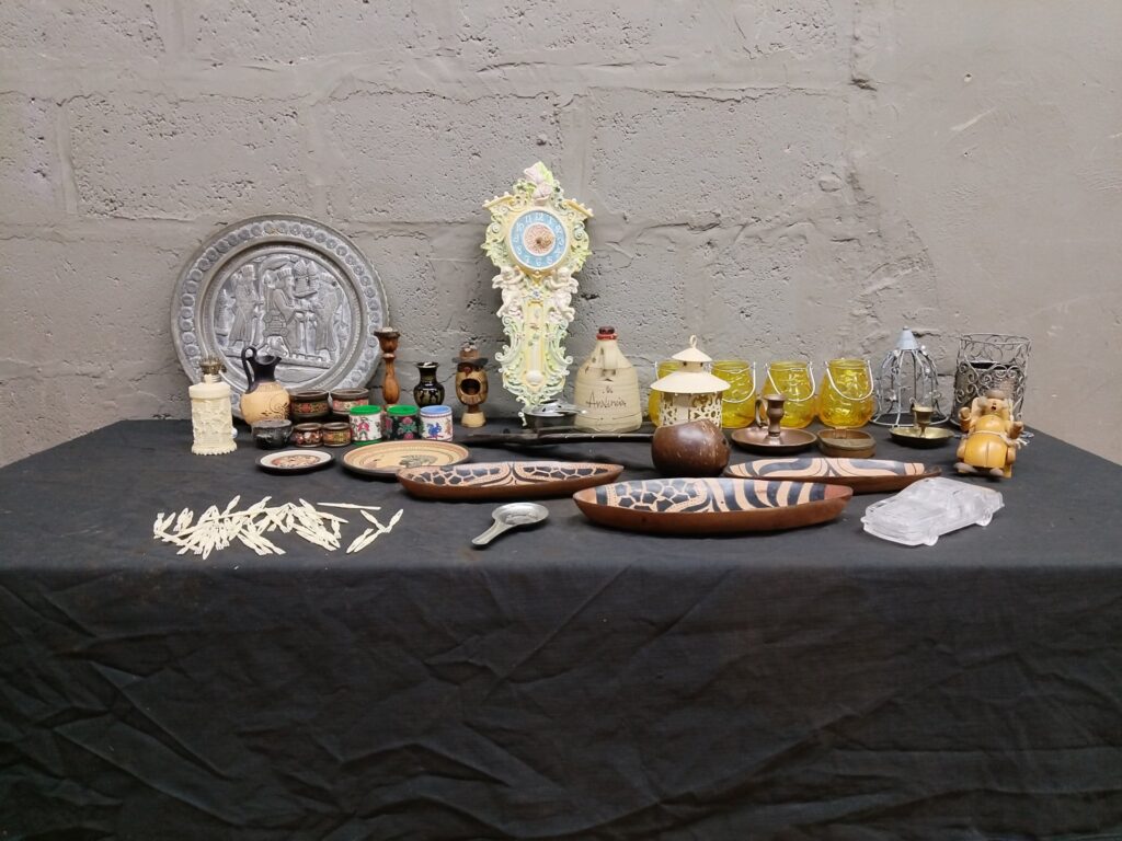 Mixed lot of 27 decorative curios — ornate wall clock, carved bowls, votives, metal plate & more (clock not working)