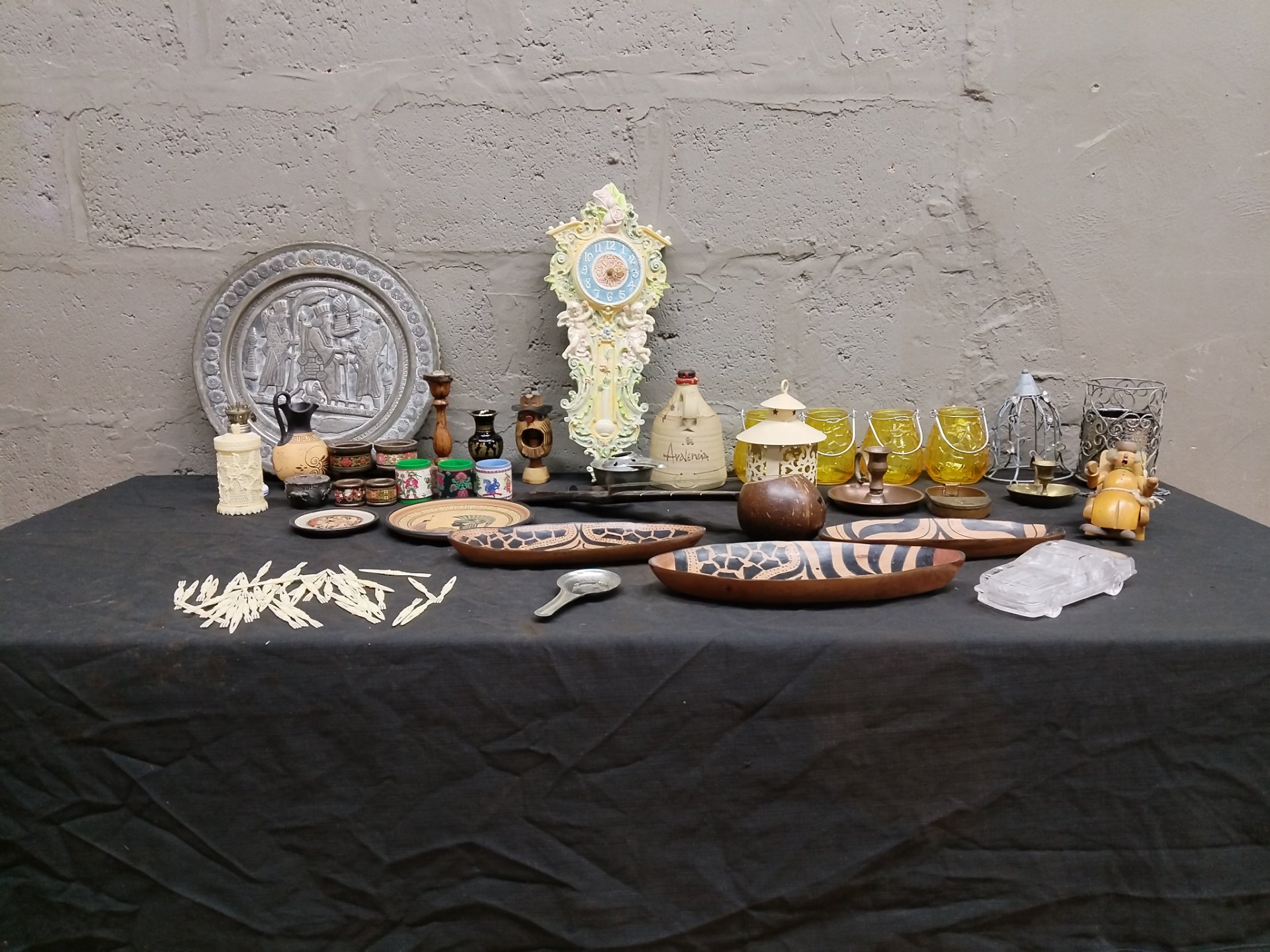 Mixed lot of 27 decorative curios — ornate wall clock, carved bowls, votives, metal plate & more (clock not working)
