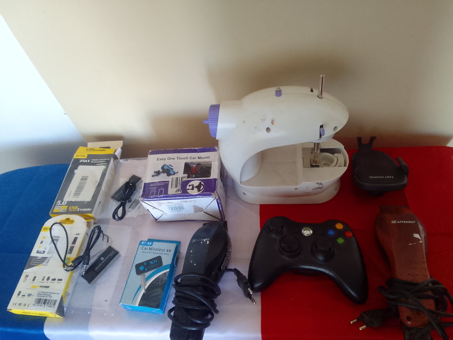 Mixed lot: White handheld mini sewing machine + assorted small electronics, controllers & chargers (untested, parts/repair)
