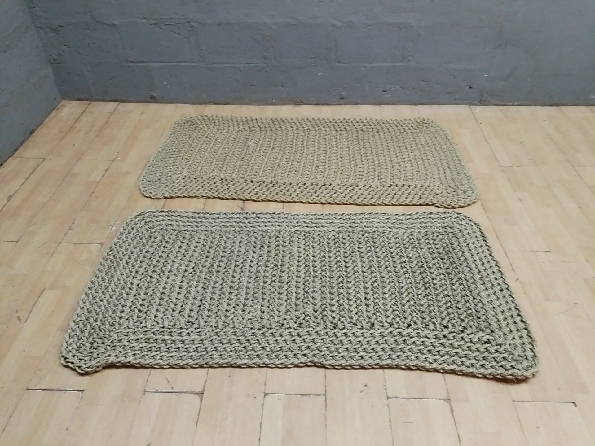 Pair of braided natural‑fibre floor mats (jute/sisal look) — 166 x 86 cm (pair)