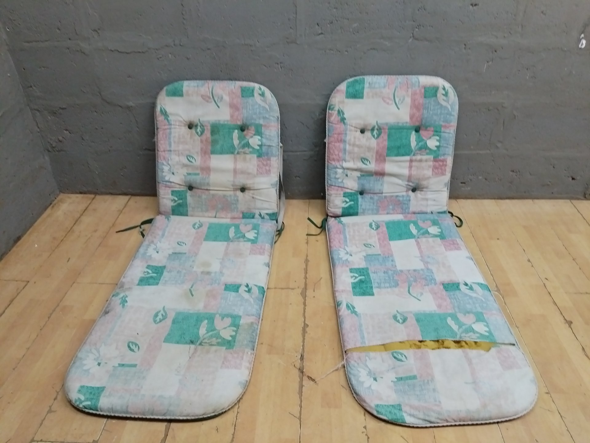 Pair of padded chair cushions (seat + back) — patterned fronts, green backs, ties; fair condition, one with large seam tear