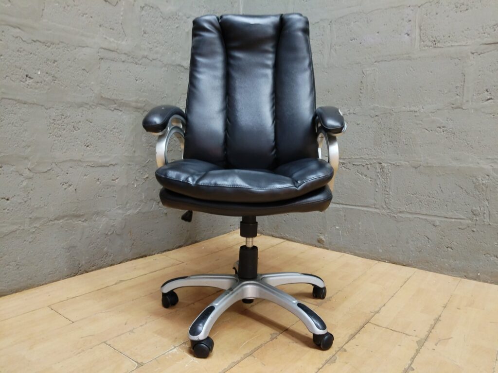 Black faux-leather high-back office swivel chair — adjustable, casters, visible armrest wear