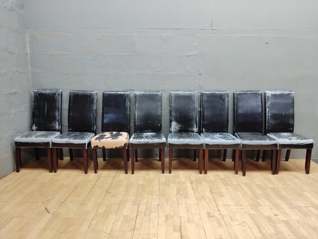 Set of 8 dining/side chairs – matching wooden frames, heavy upholstery wear, one seat with large missing cover