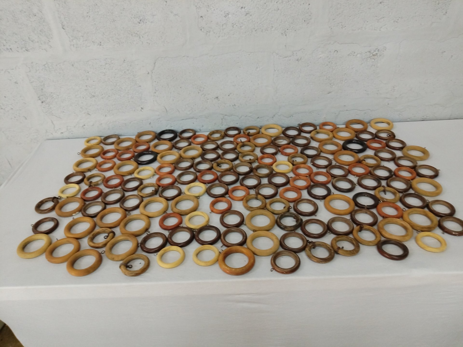 Lot of approx. 80 Wooden Curtain Rings — Mixed warm finishes, many with metal hooks, used condition