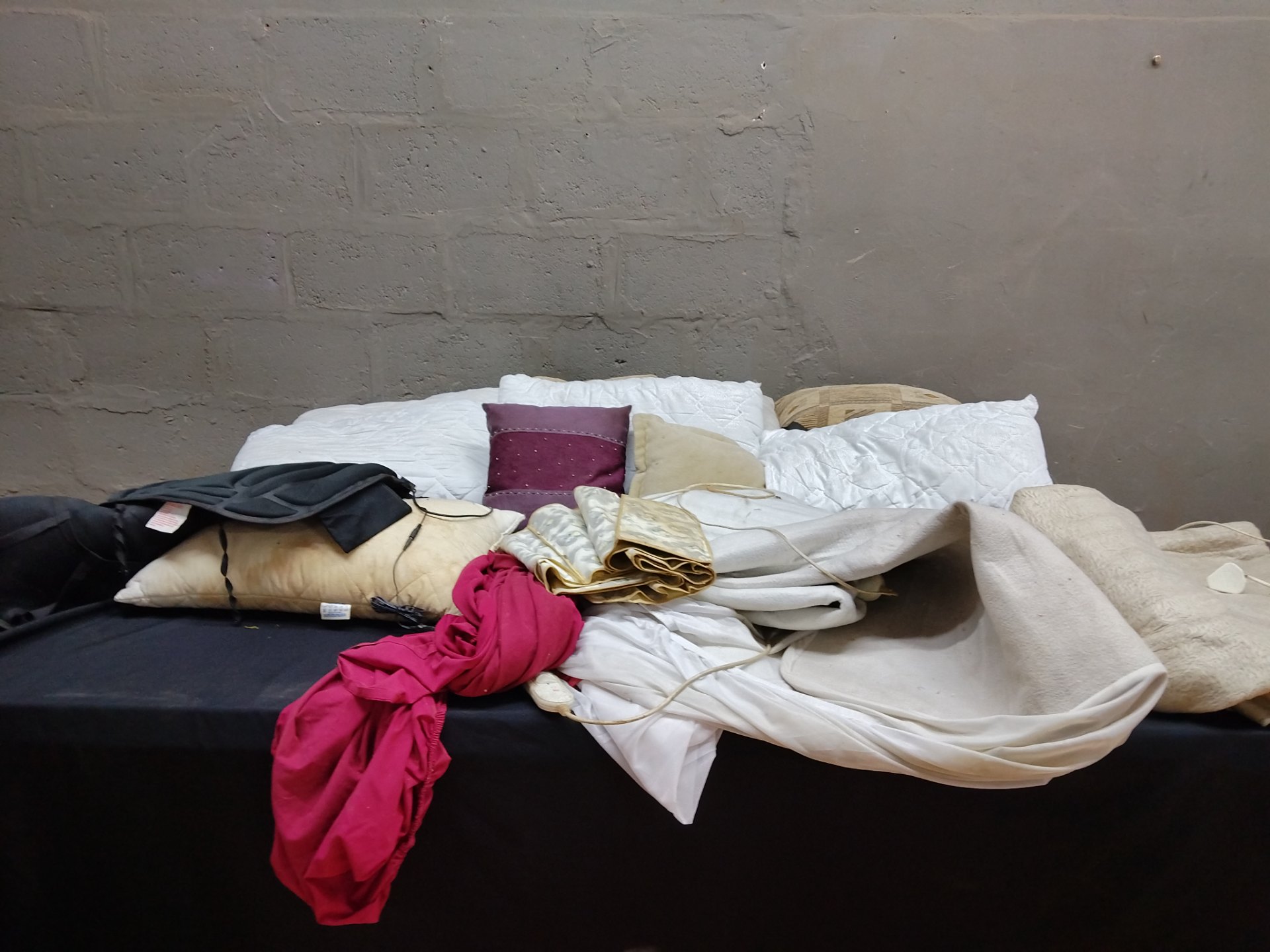 Mixed lot: Assorted bedding, cushions, throws & electric heating pad (approx. 12 items) — heavy soiling, heating pad NOT working