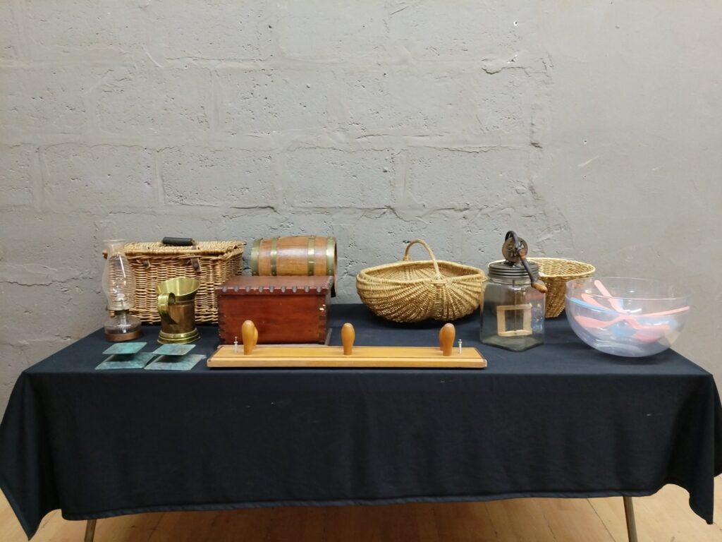 Mixed lot of 11 household & decorative items — wicker baskets, wooden barrel dispenser, glass jar with hand-crank, brass mug, oil lamp, wooden box
