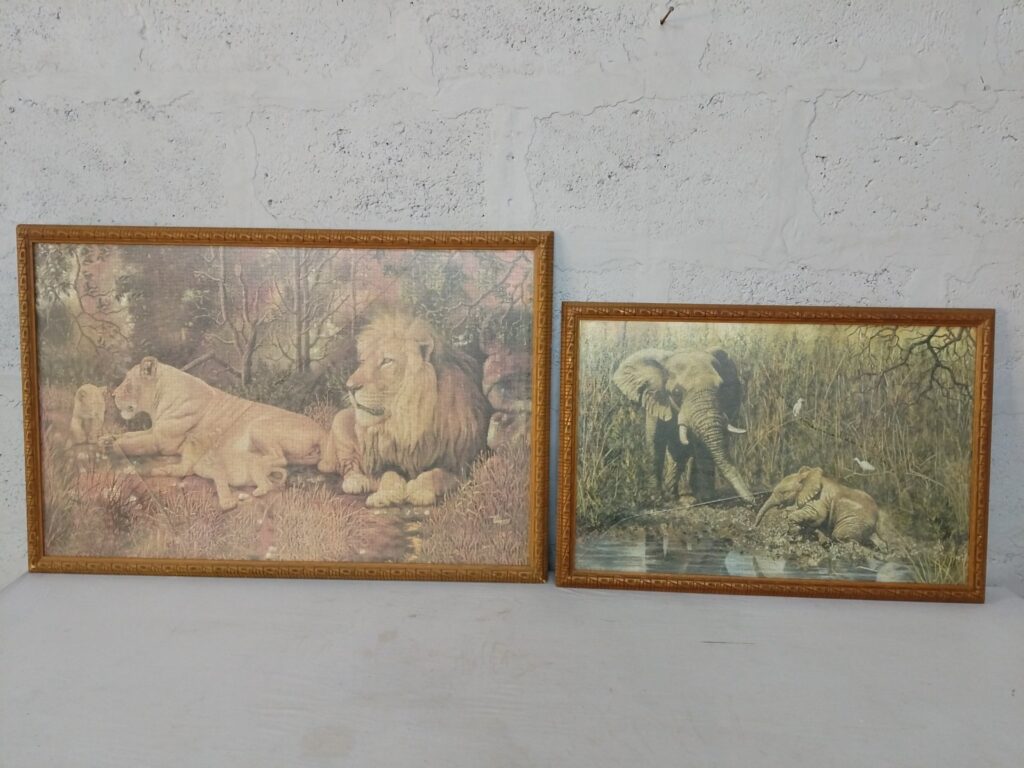 Pair of framed completed jigsaw puzzles — lion and elephant scenes, carved wooden frames (sizes 96×63 cm & 75×52 cm)