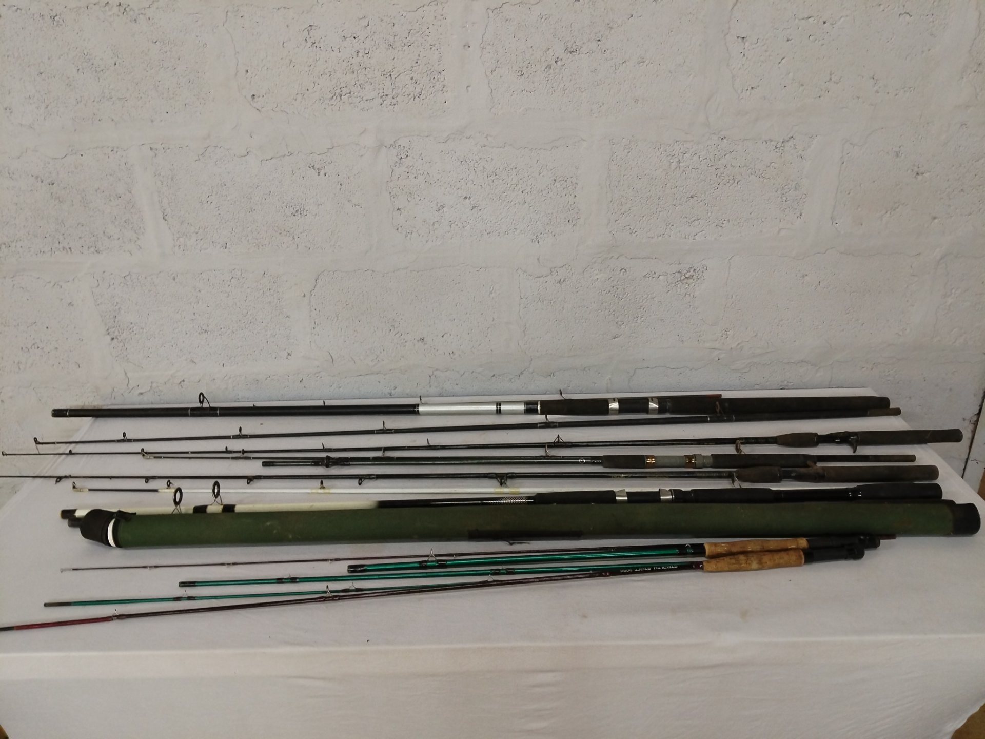 Lot of 8 used fishing rods & sections with green rod tube — mixed condition, some repairs