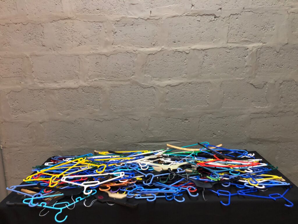 Bulk mixed plastic hangers — approx. 102 pieces, assorted colours, used condition